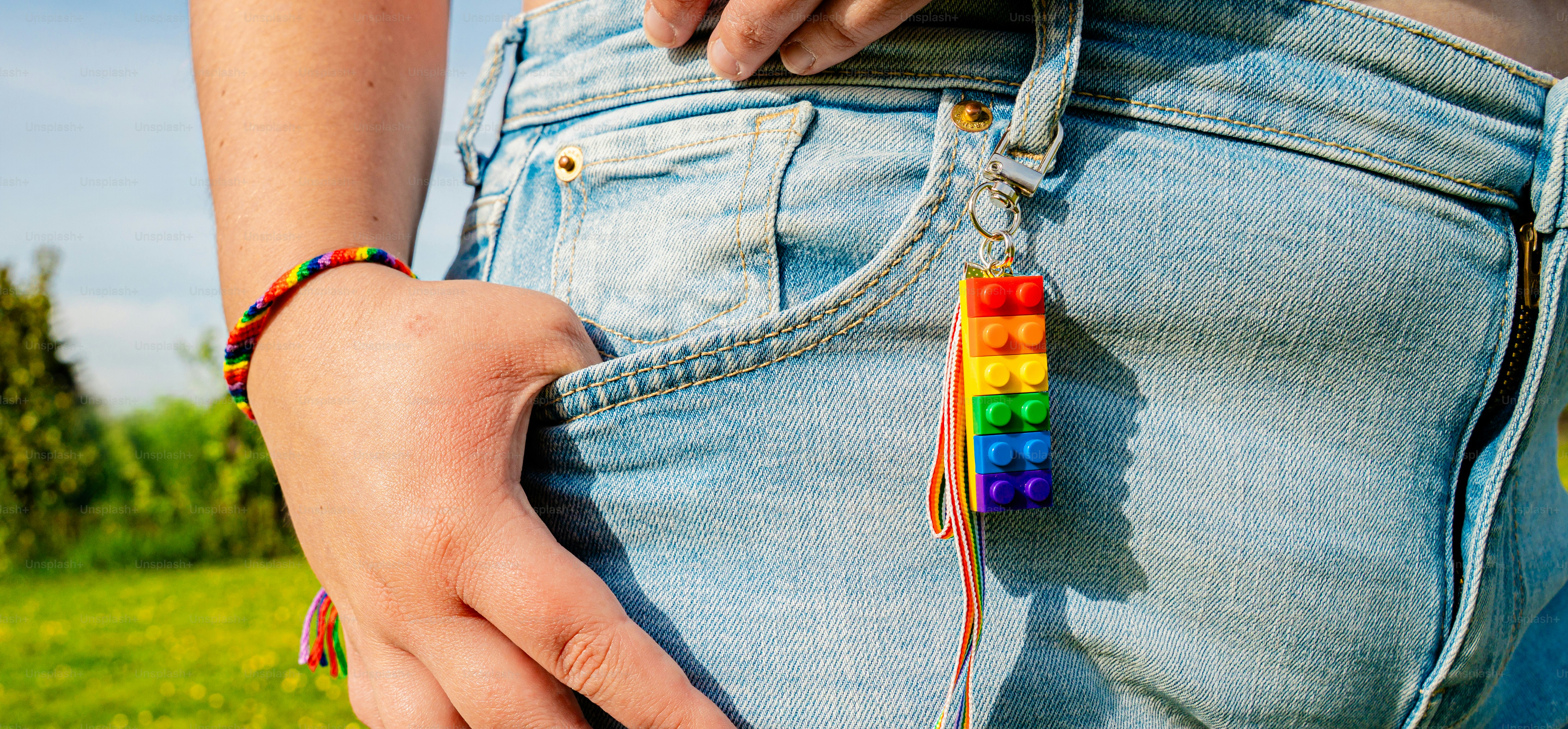 Portachiavi arcobaleno attaccato alla tasca dei jeans di jeans