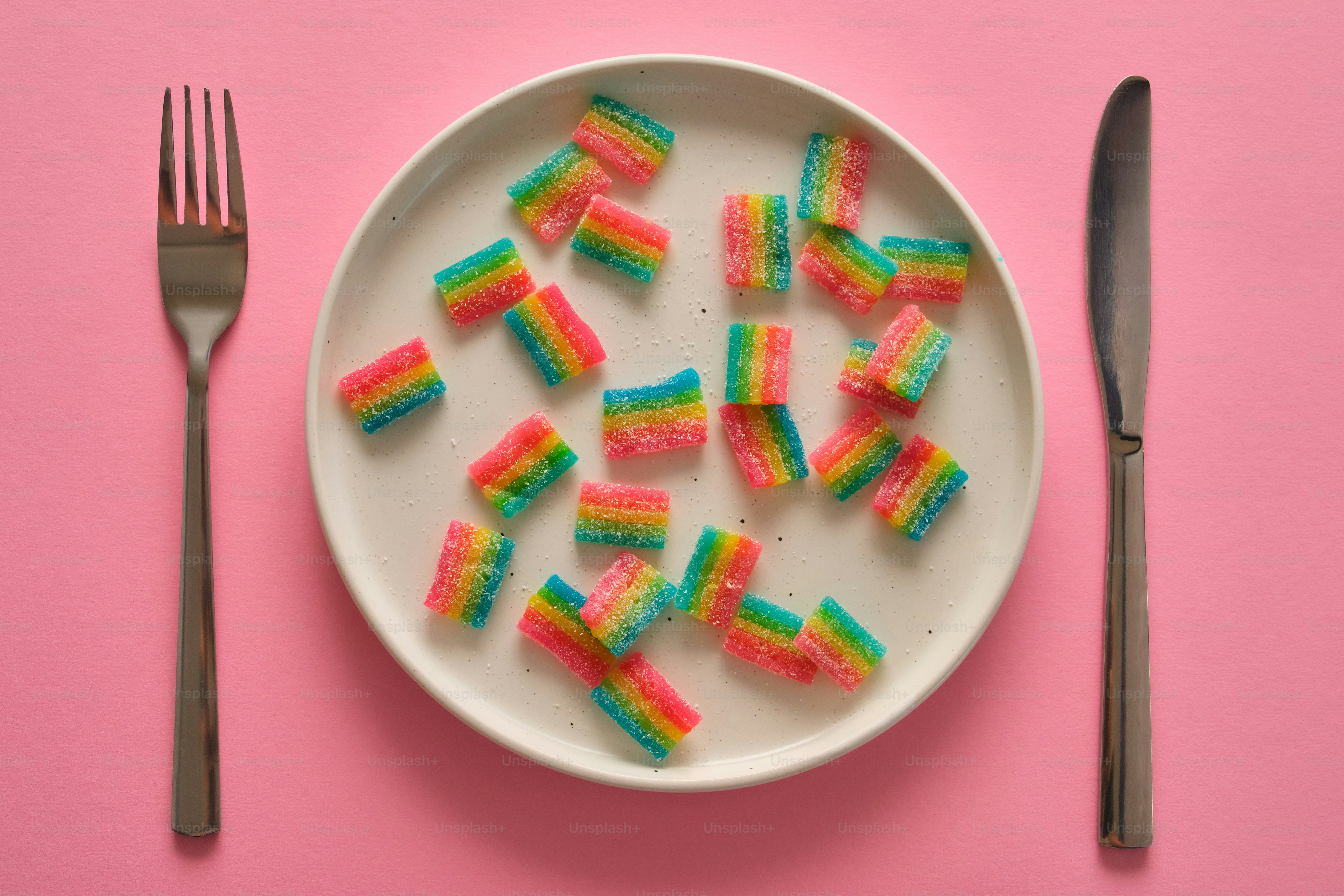 Rainbow candy strips on a plate with cutlery