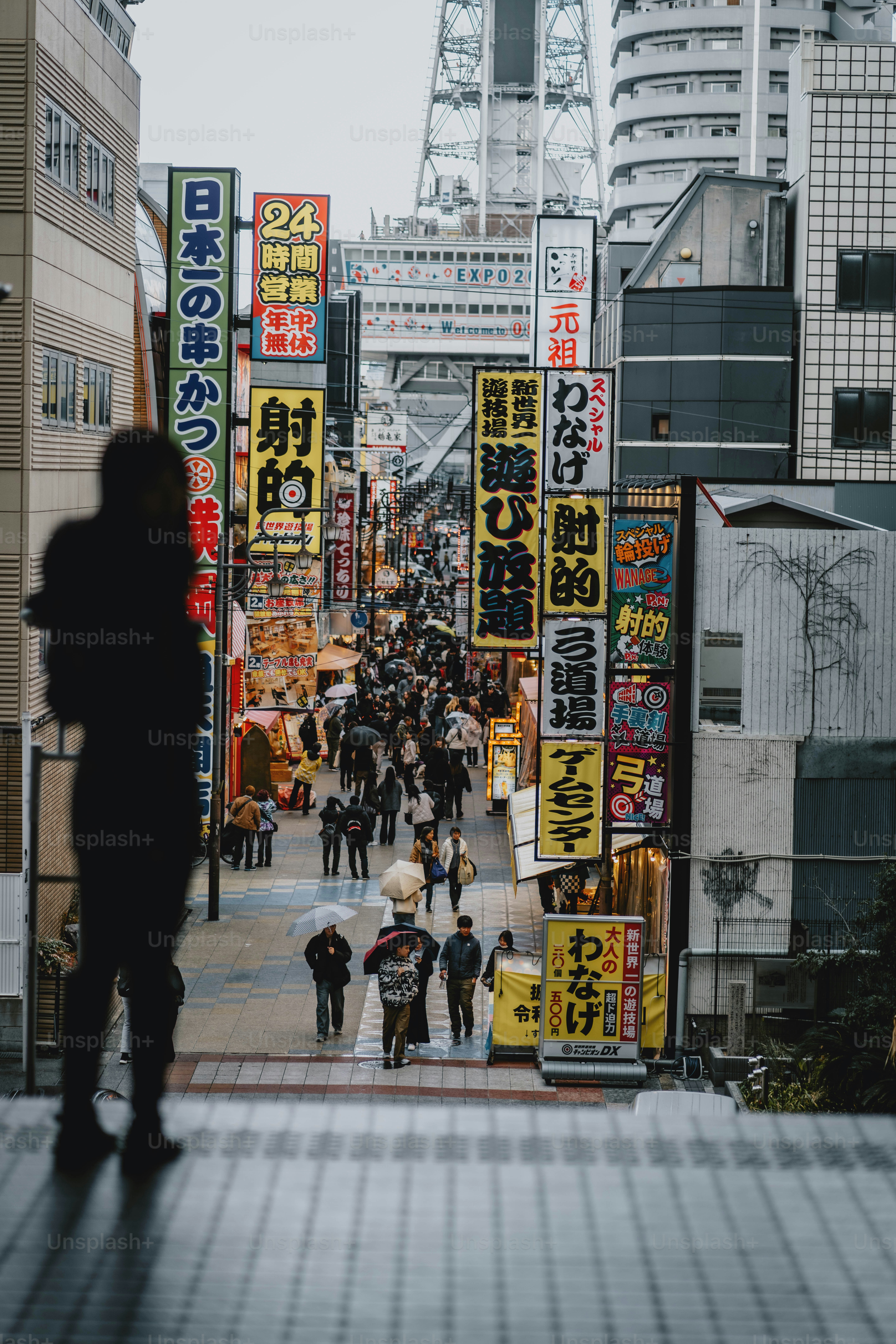 Calle concurrida en Japón con muchos carteles iluminados.