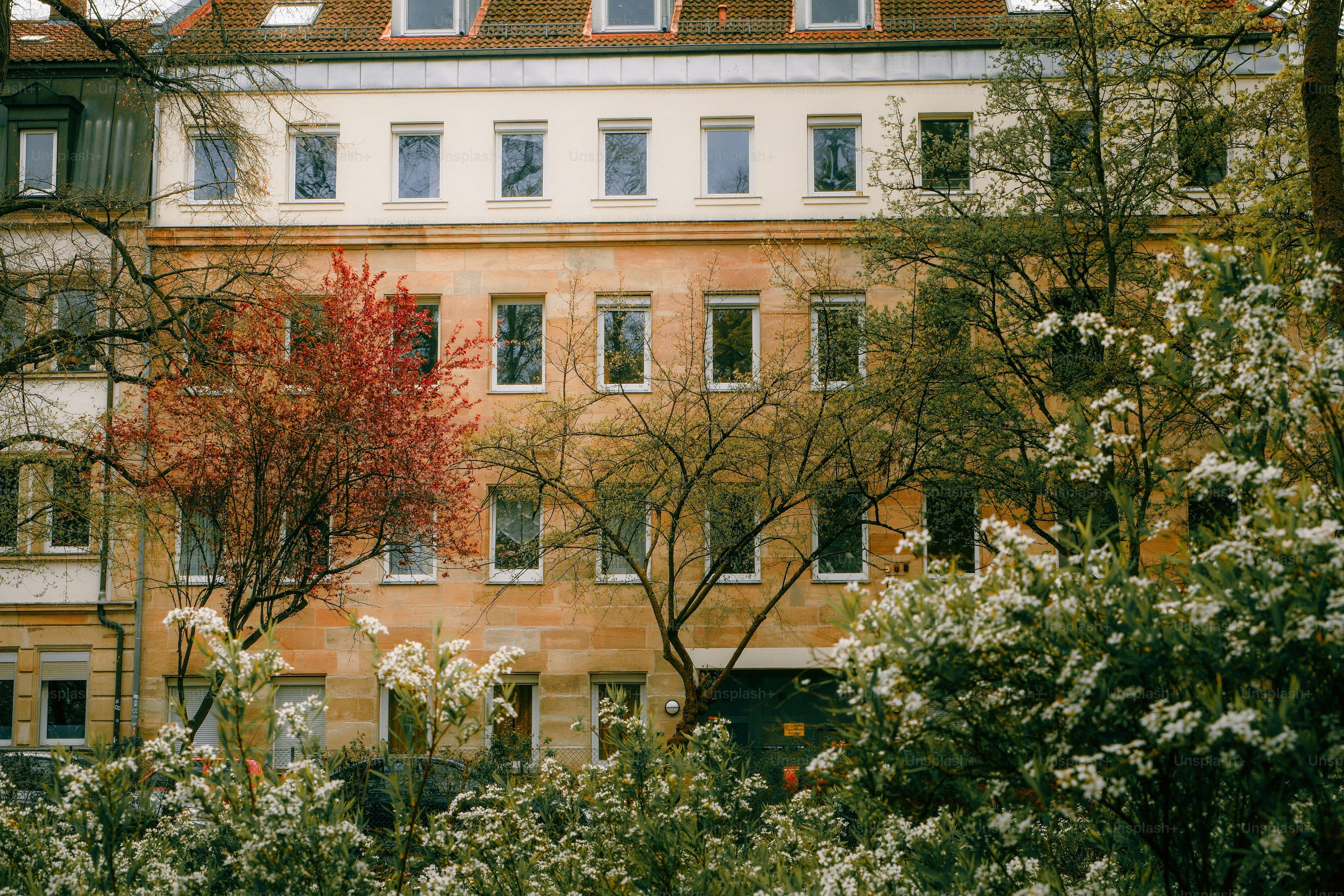 Fachada de edificio de apartamentos con árboles y flores