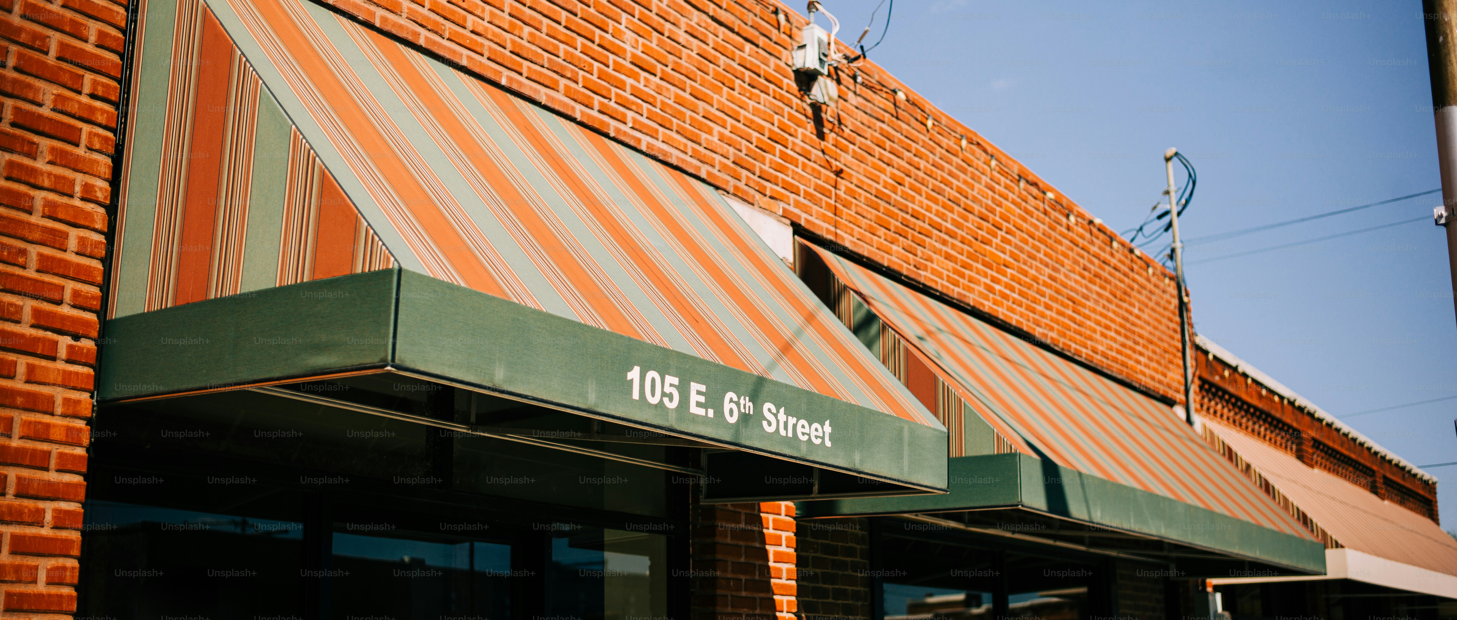 Striped awnings over brick building on sunny day
