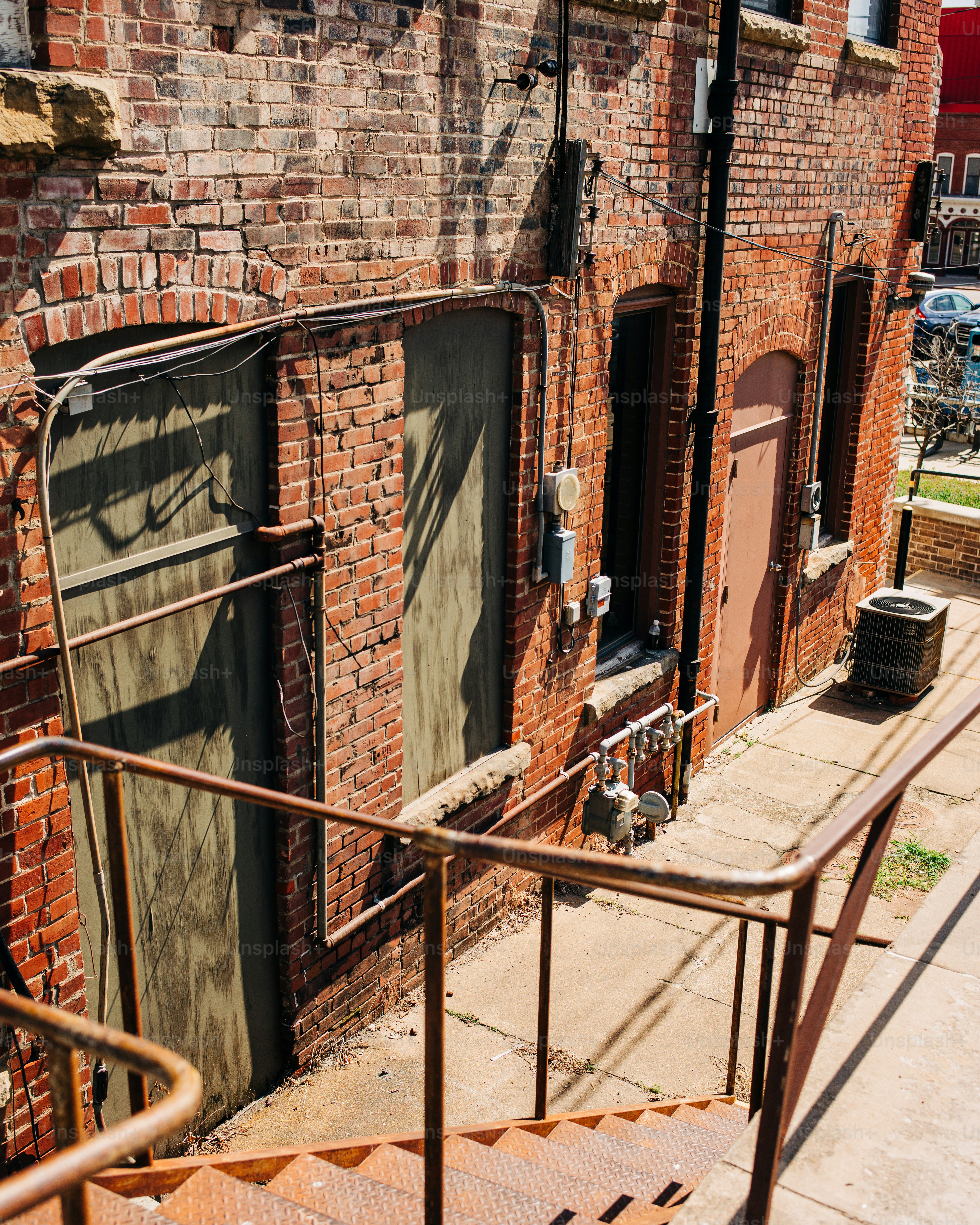 錆びた階段がレンガ造りの建物と扉のそばを下りている。