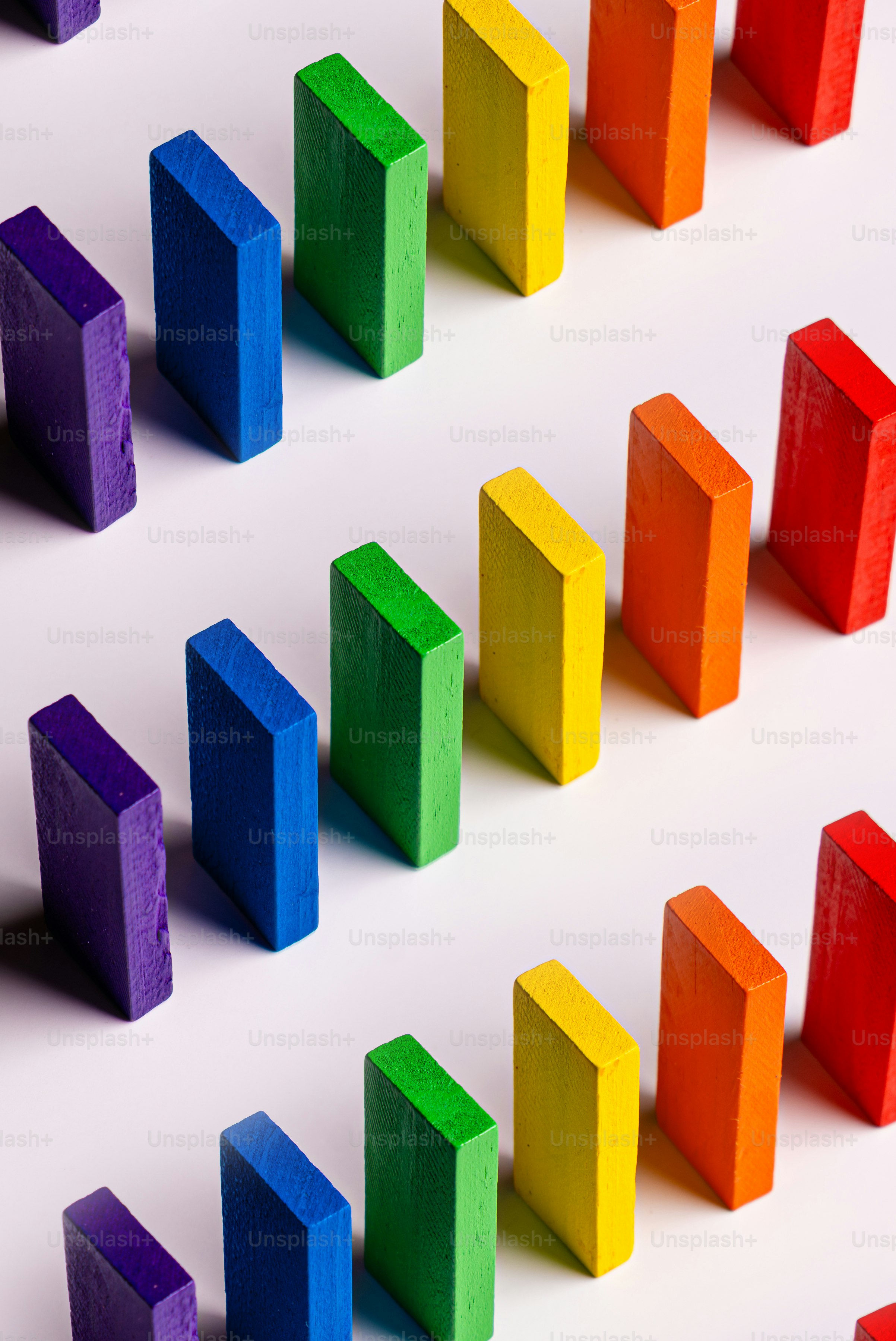 Colorful clothespins arranged in diagonal rows on pink background ...