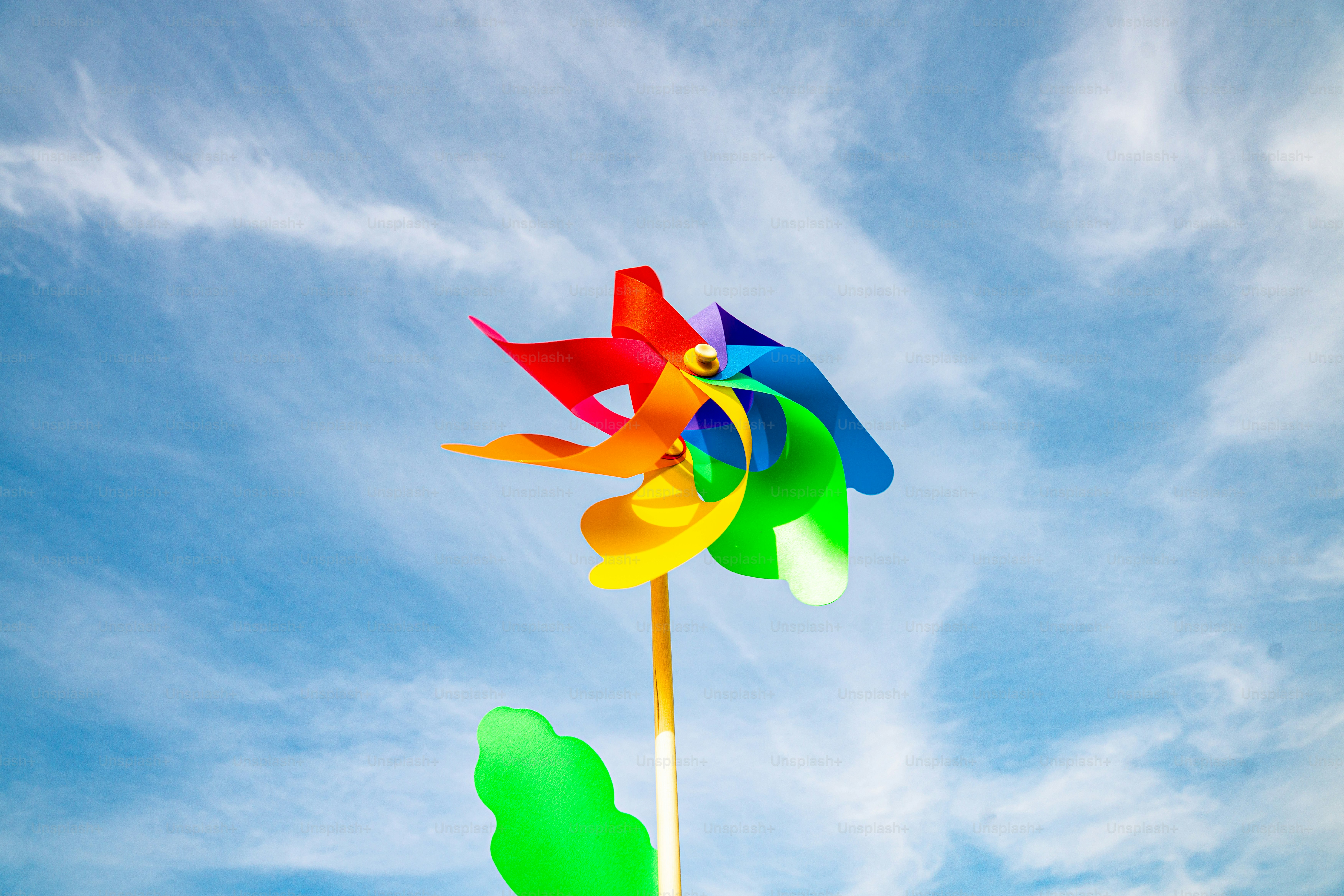 A colorful pinwheel spins against a cloudy blue sky. photo – Summer ...