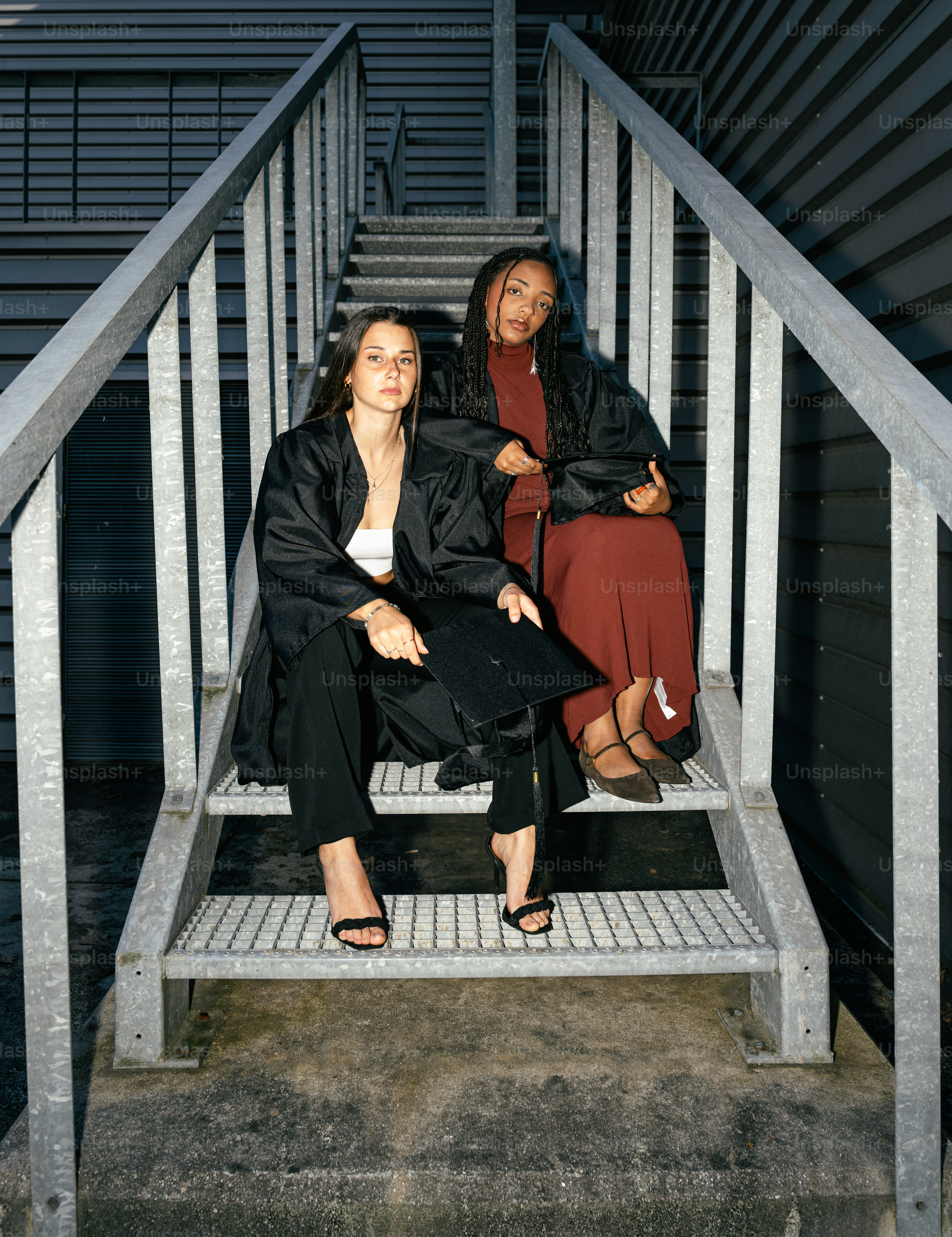 Two graduates in gowns walk up stairs photo – Success Image on Unsplash