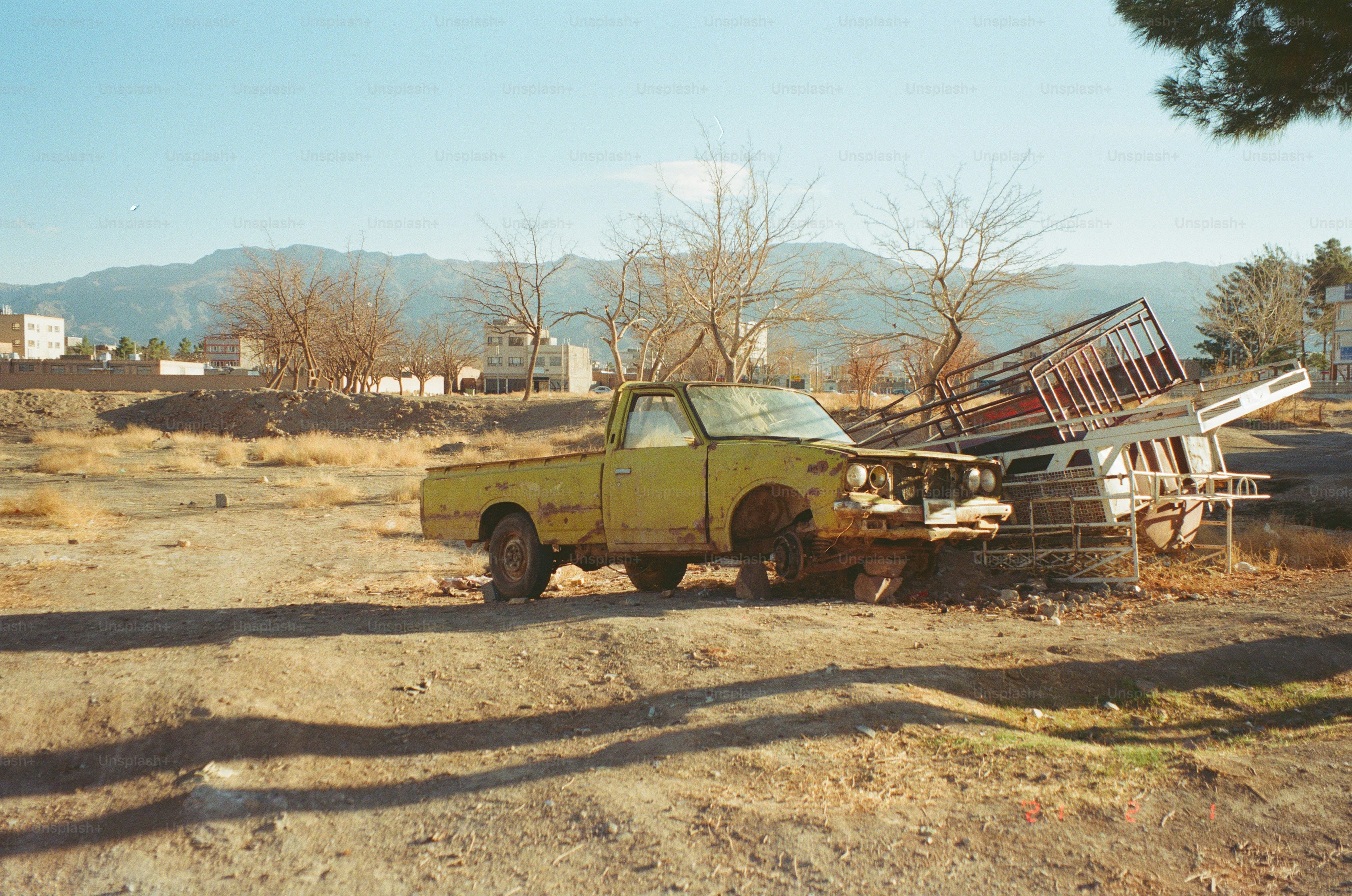 Un vieux pick-up jaune est abandonné à l’extérieur.