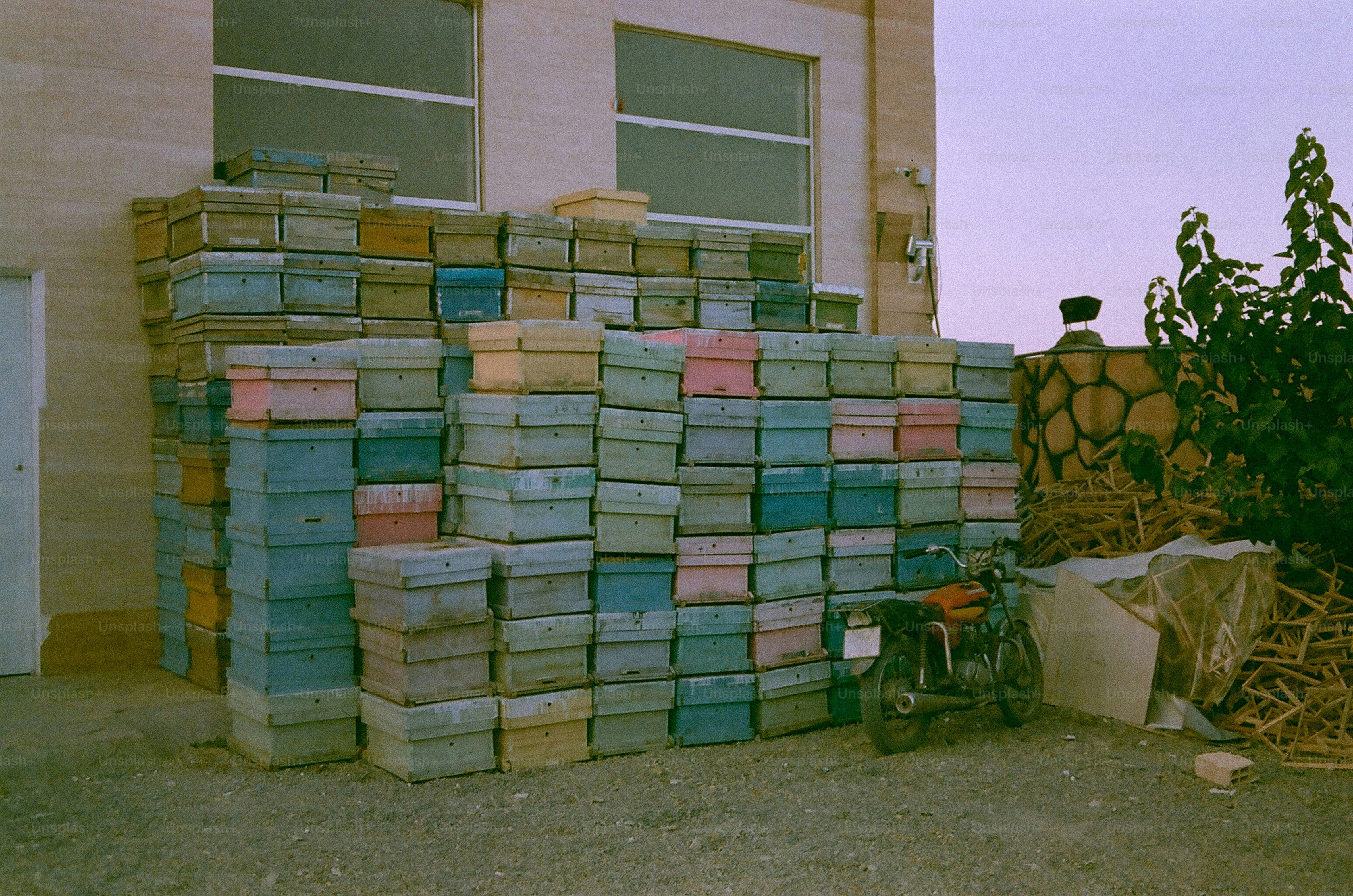 Des piles de caisses en plastique colorées devant un bâtiment.