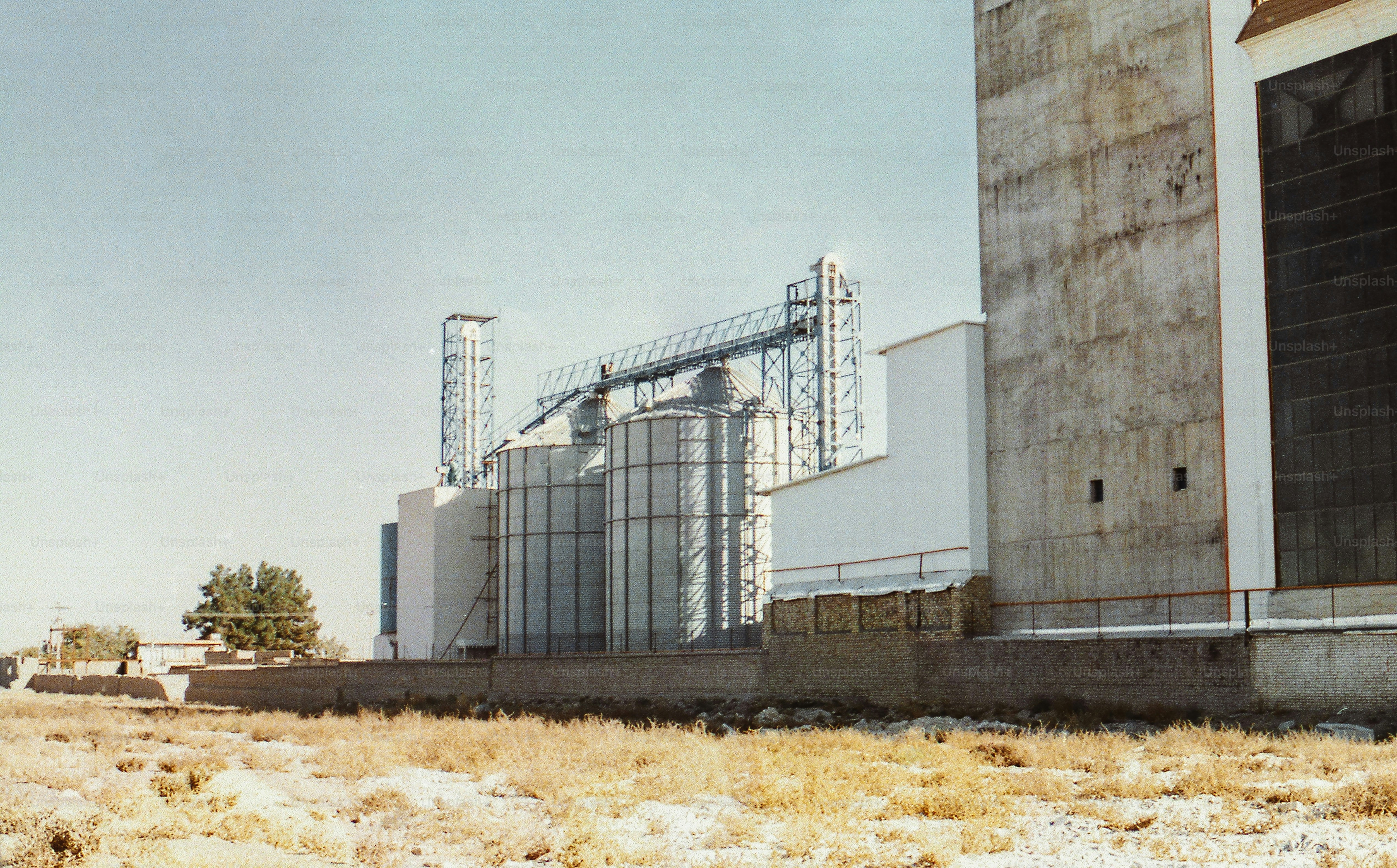 Silos industriels et bâtiments sous un ciel dégagé.