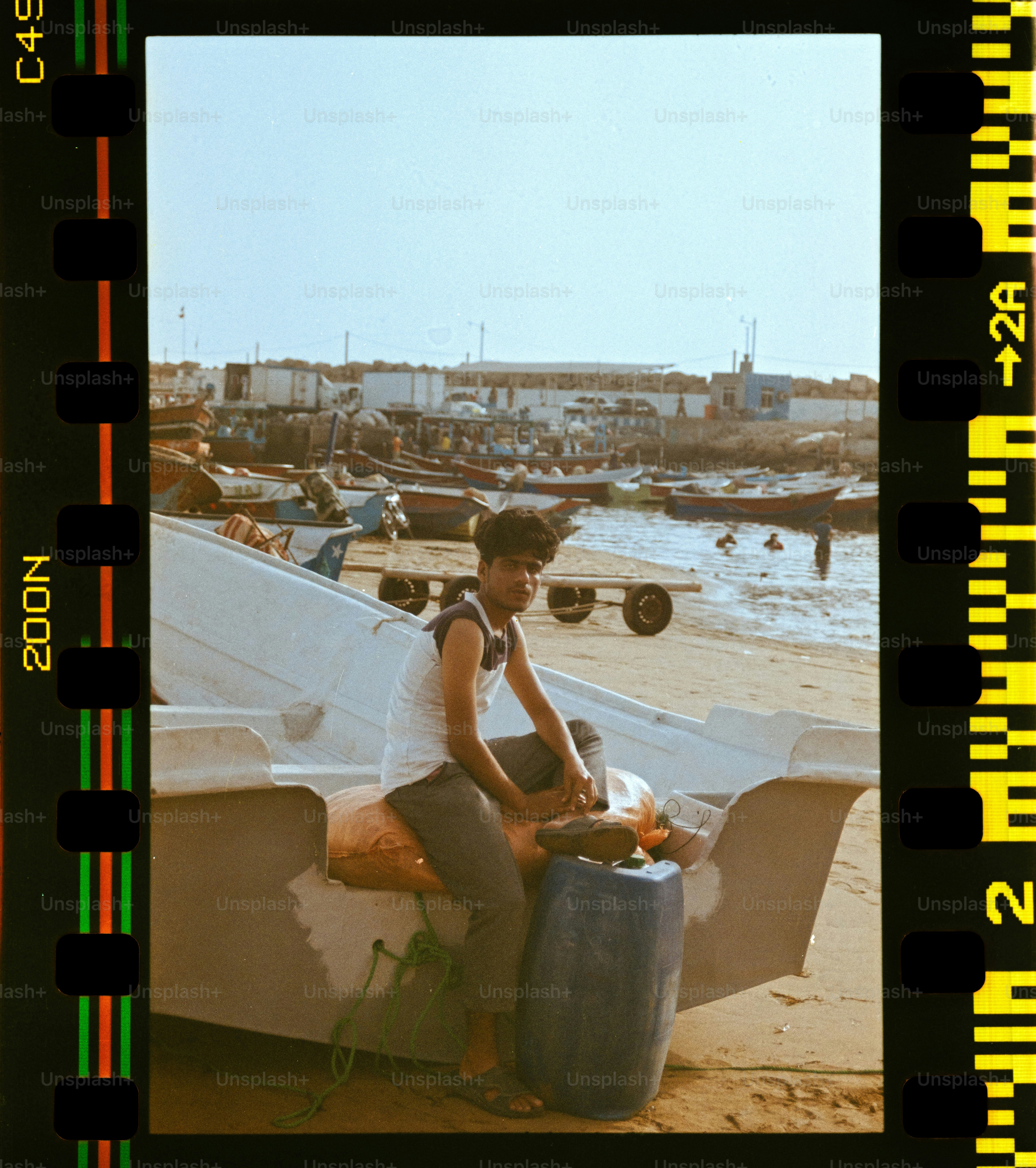 Jeune homme assis sur un bateau au bord de l’eau