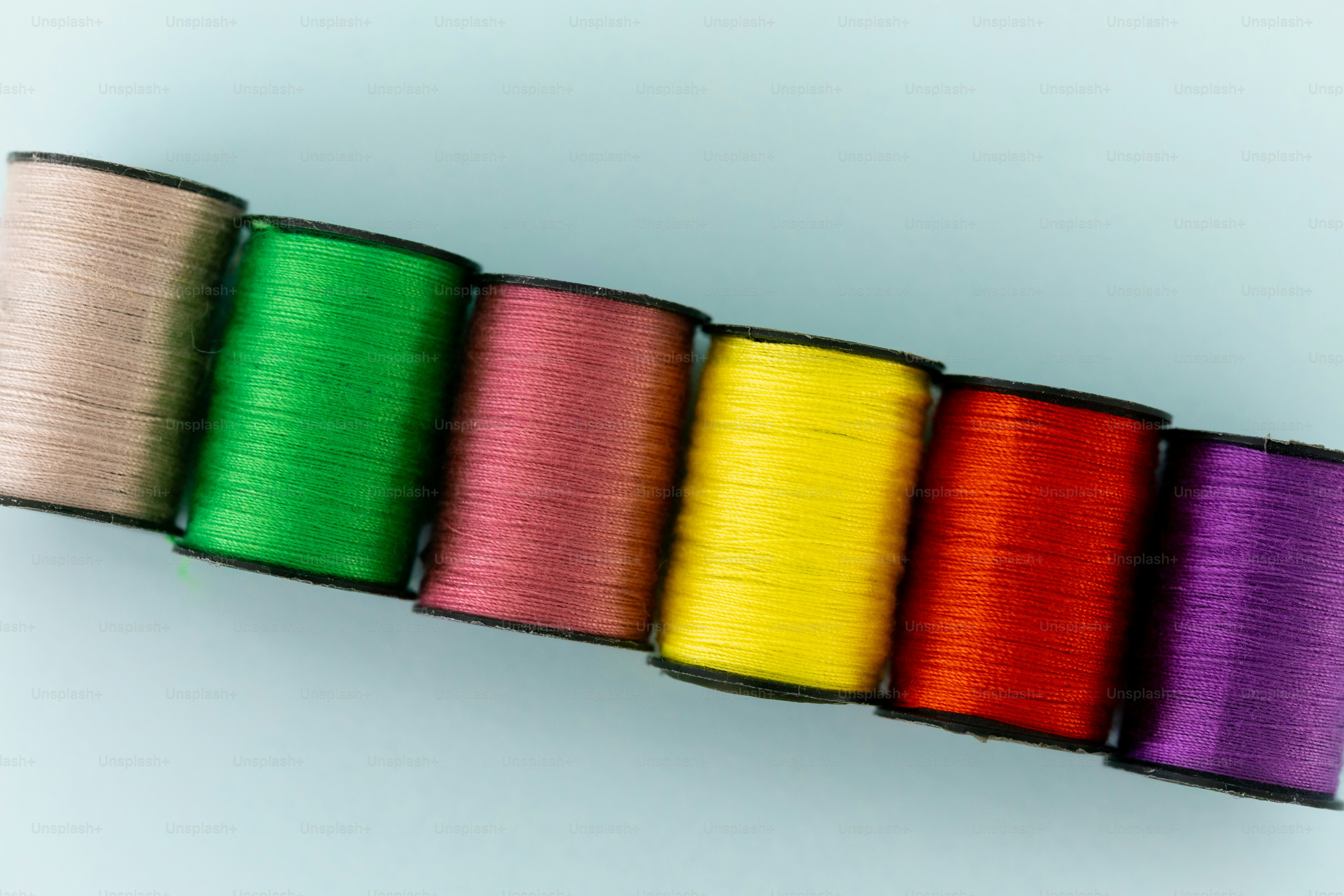 Six spools of colorful thread on a green background photo – Fabric ...