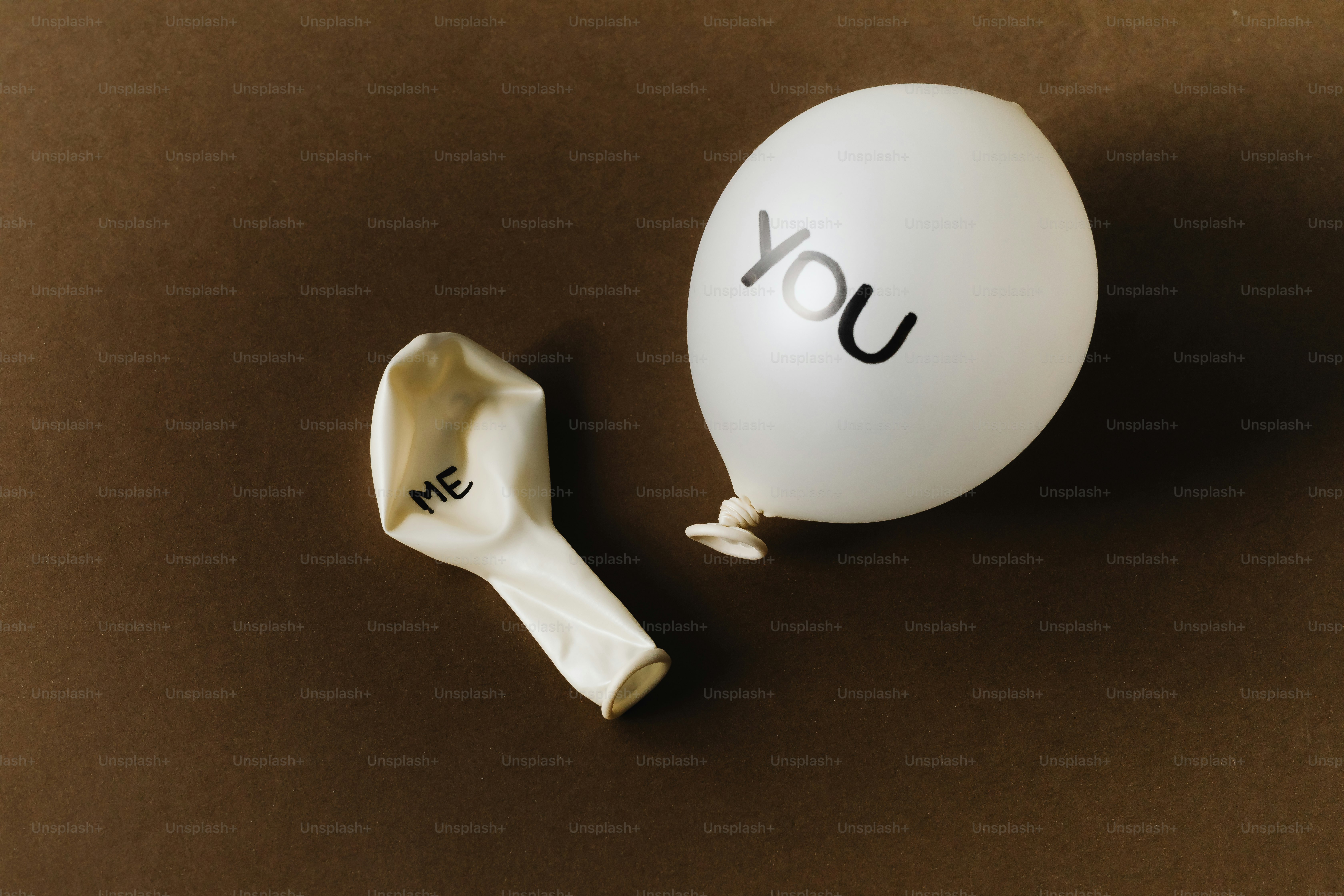 Balon kempes berlabel "aku" di sebelah balon yang mengembang berlabel "kamu"