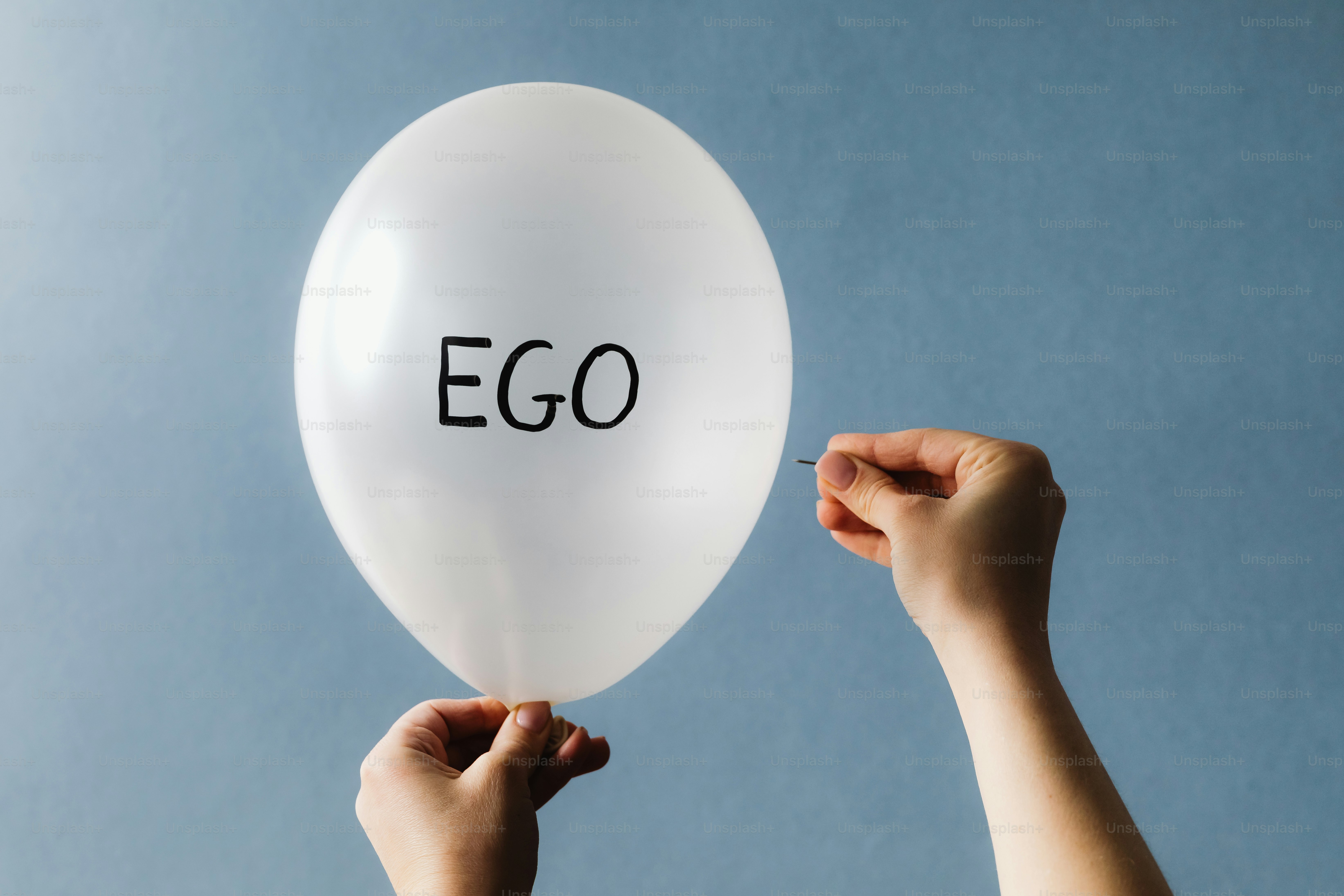 Palloncino bianco con la parola ego che viene scoppiata