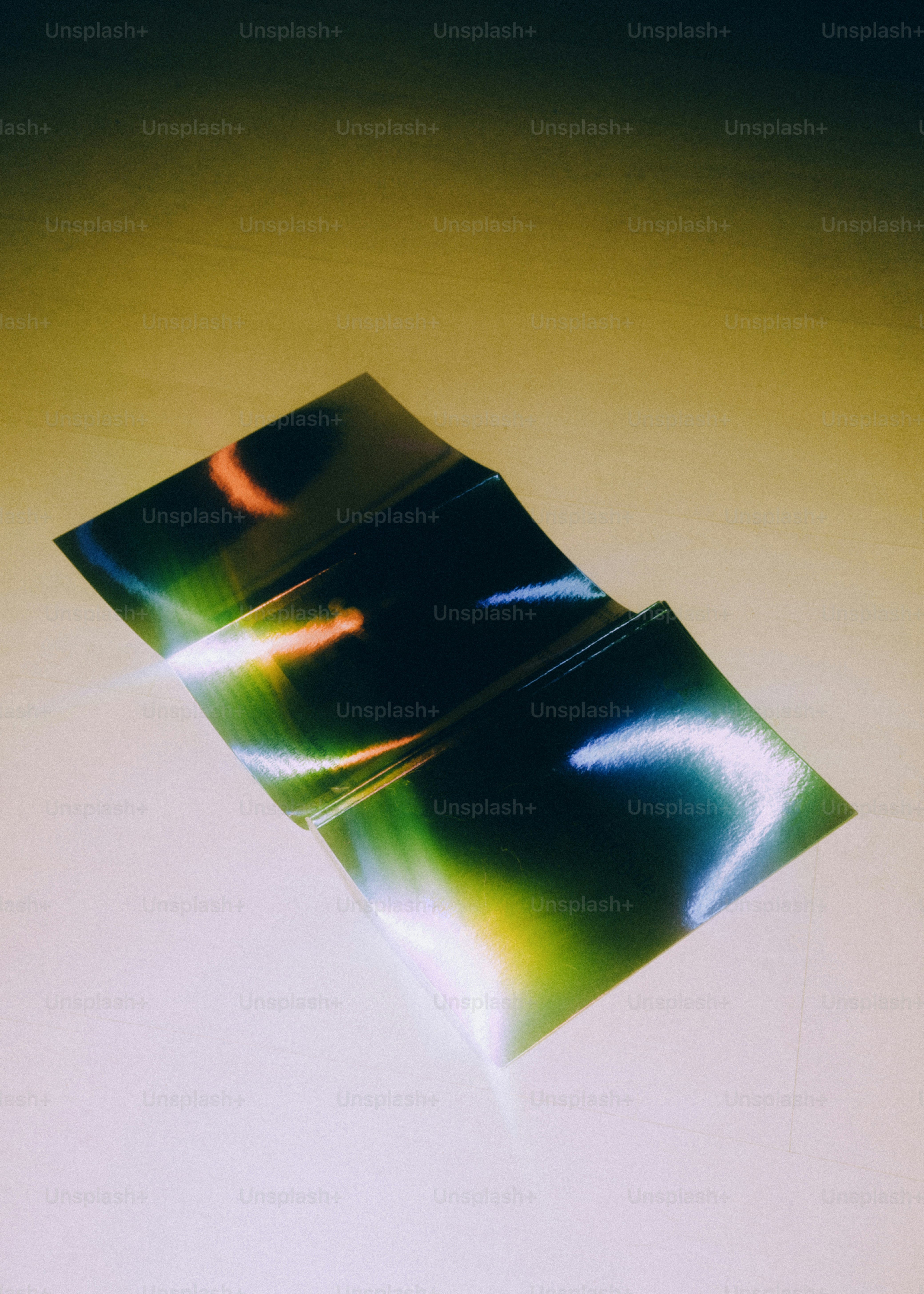 Three folded iridescent papers with colorful light reflections photo ...