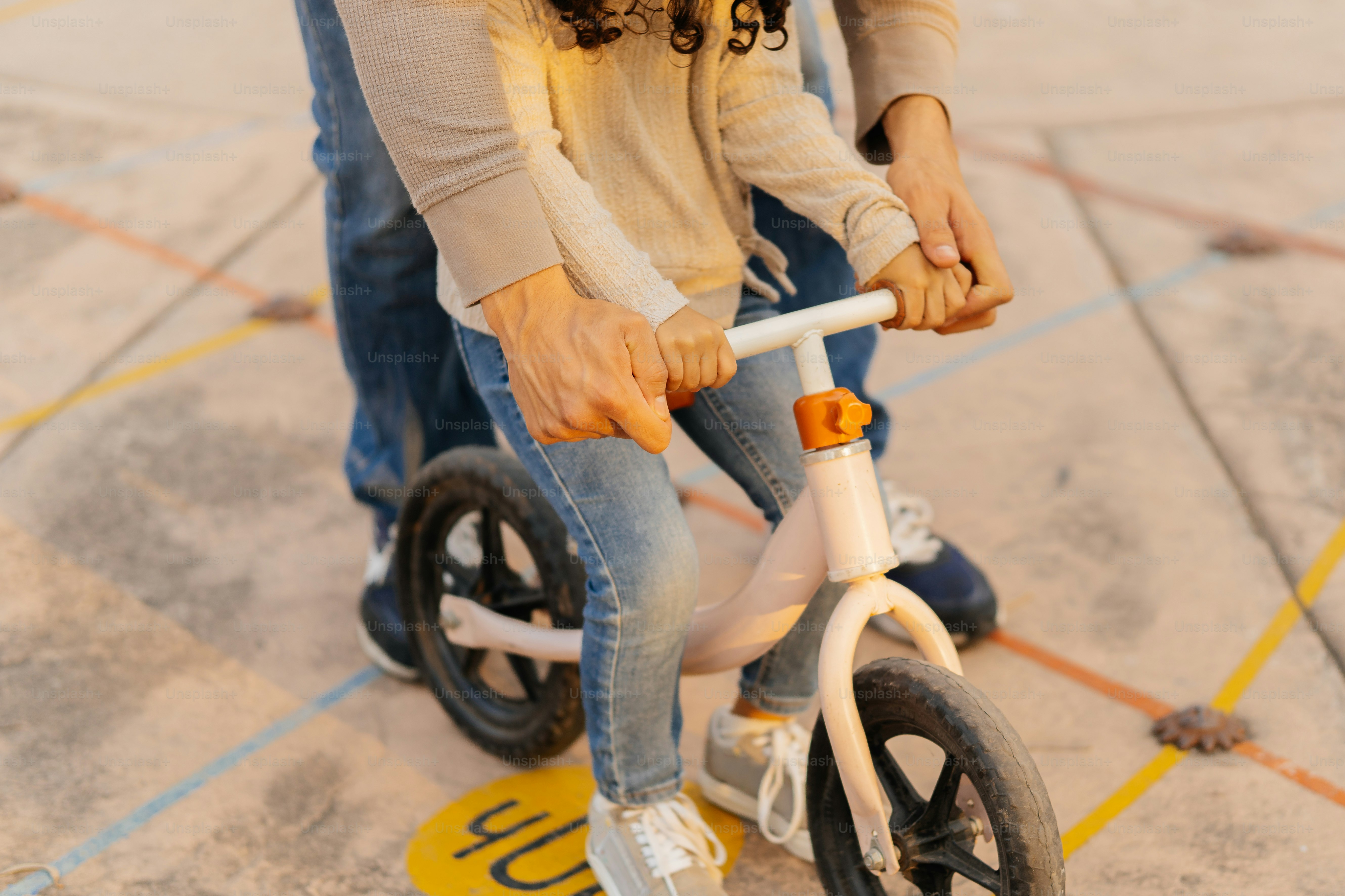Adulte aidant un enfant à faire du pedal