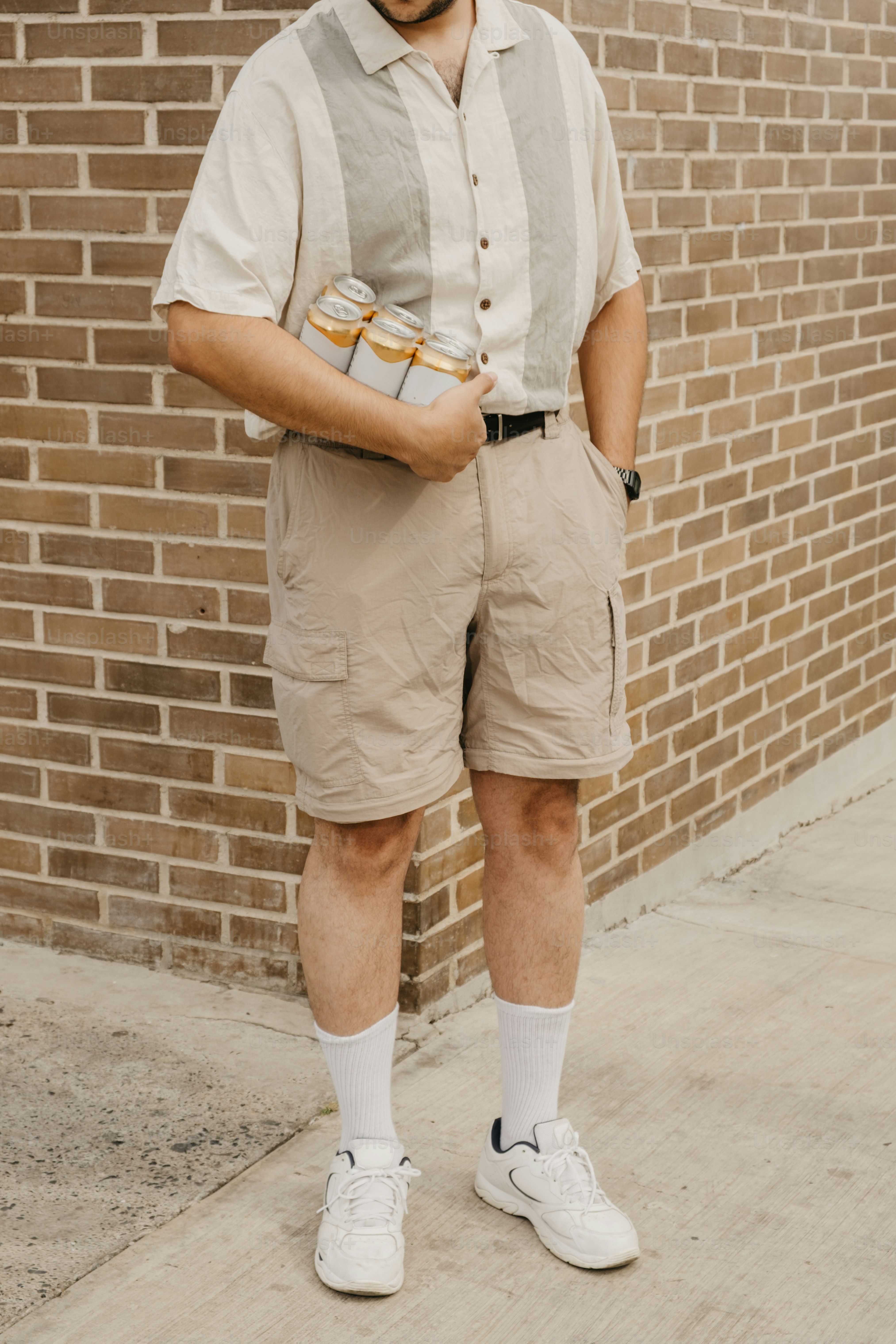 Man in casual clothing holding cans of drink