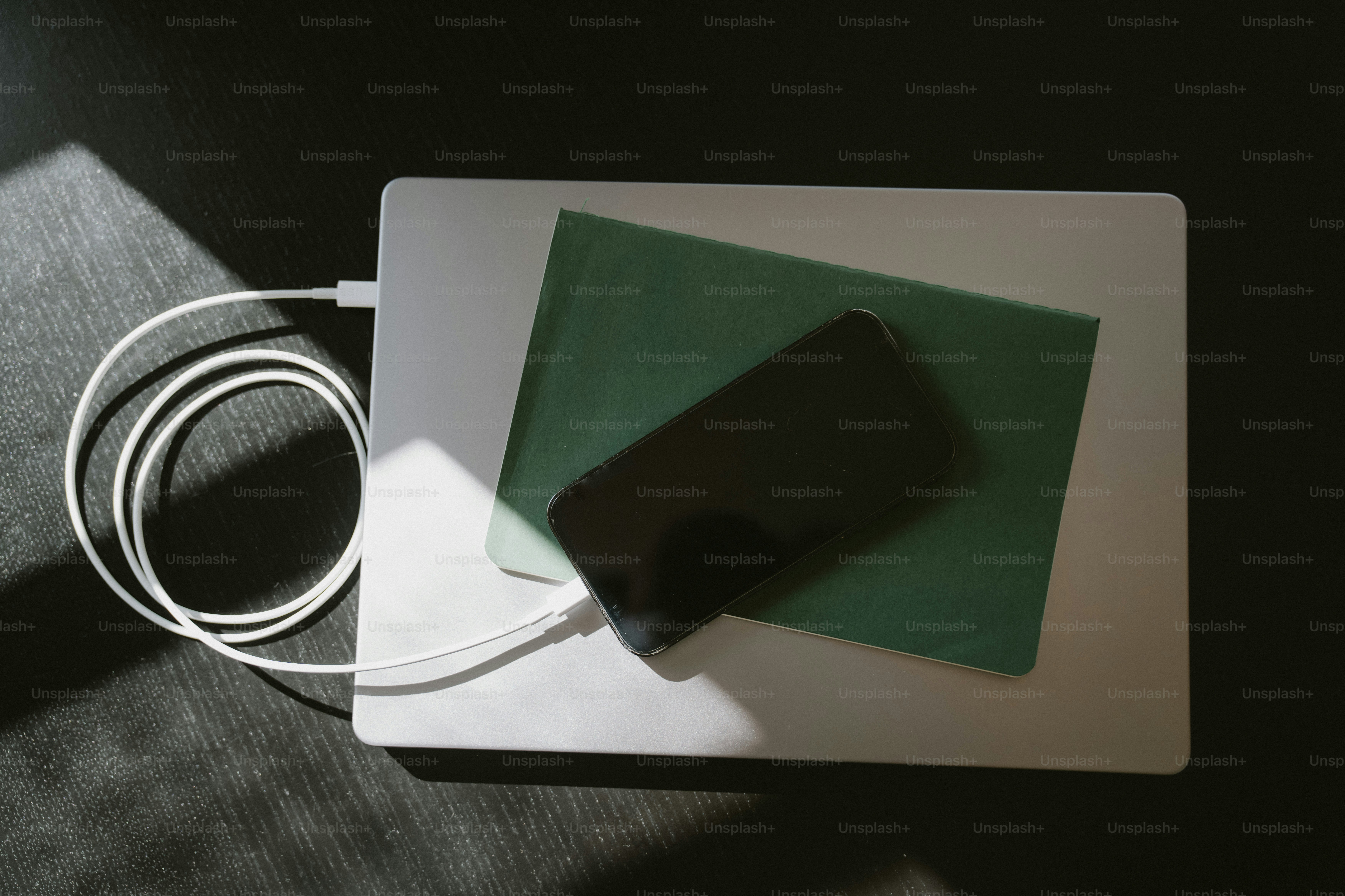 Portatile con telefono e quaderno su superficie scura