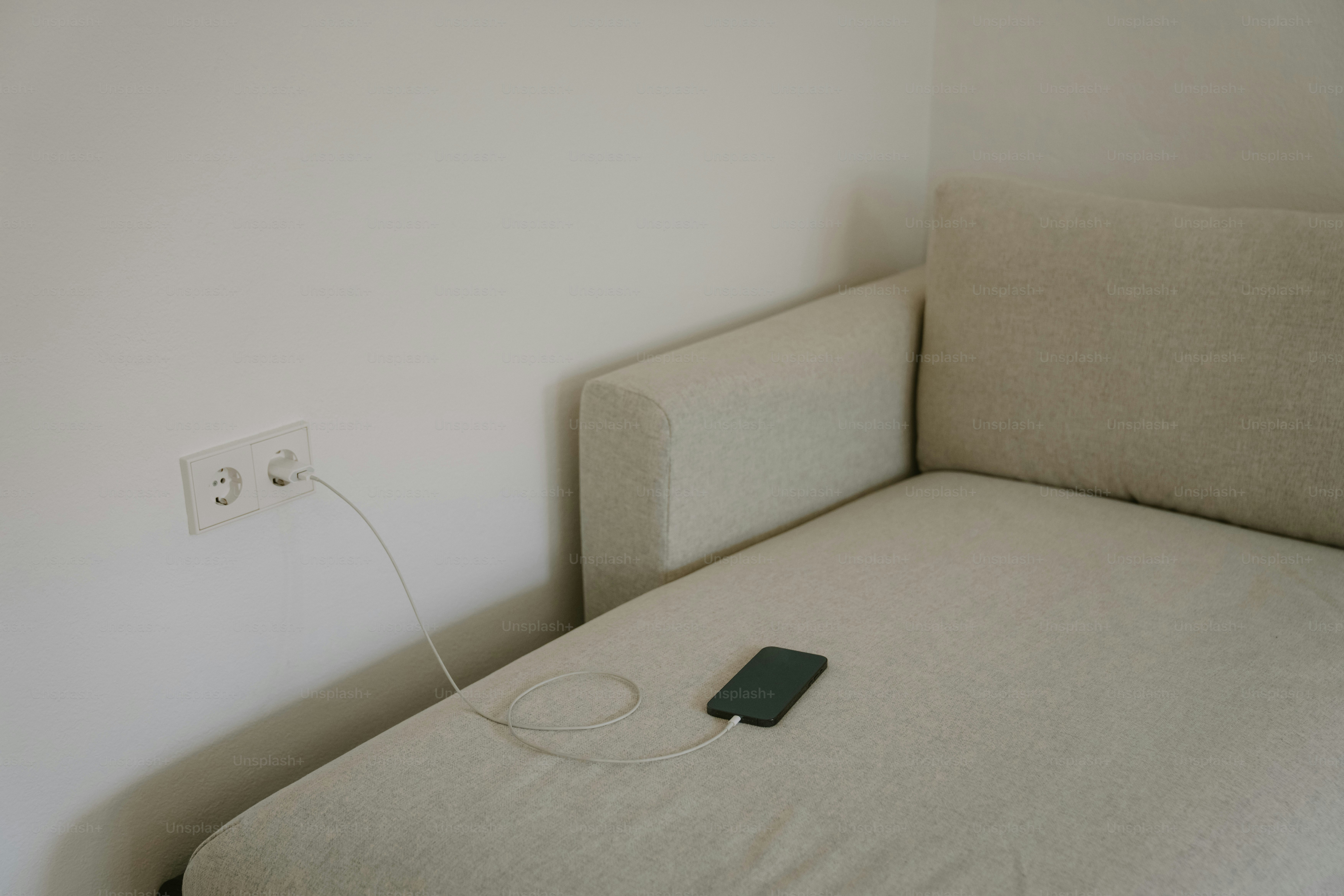 Ricarica dello smartphone su un divano chiaro