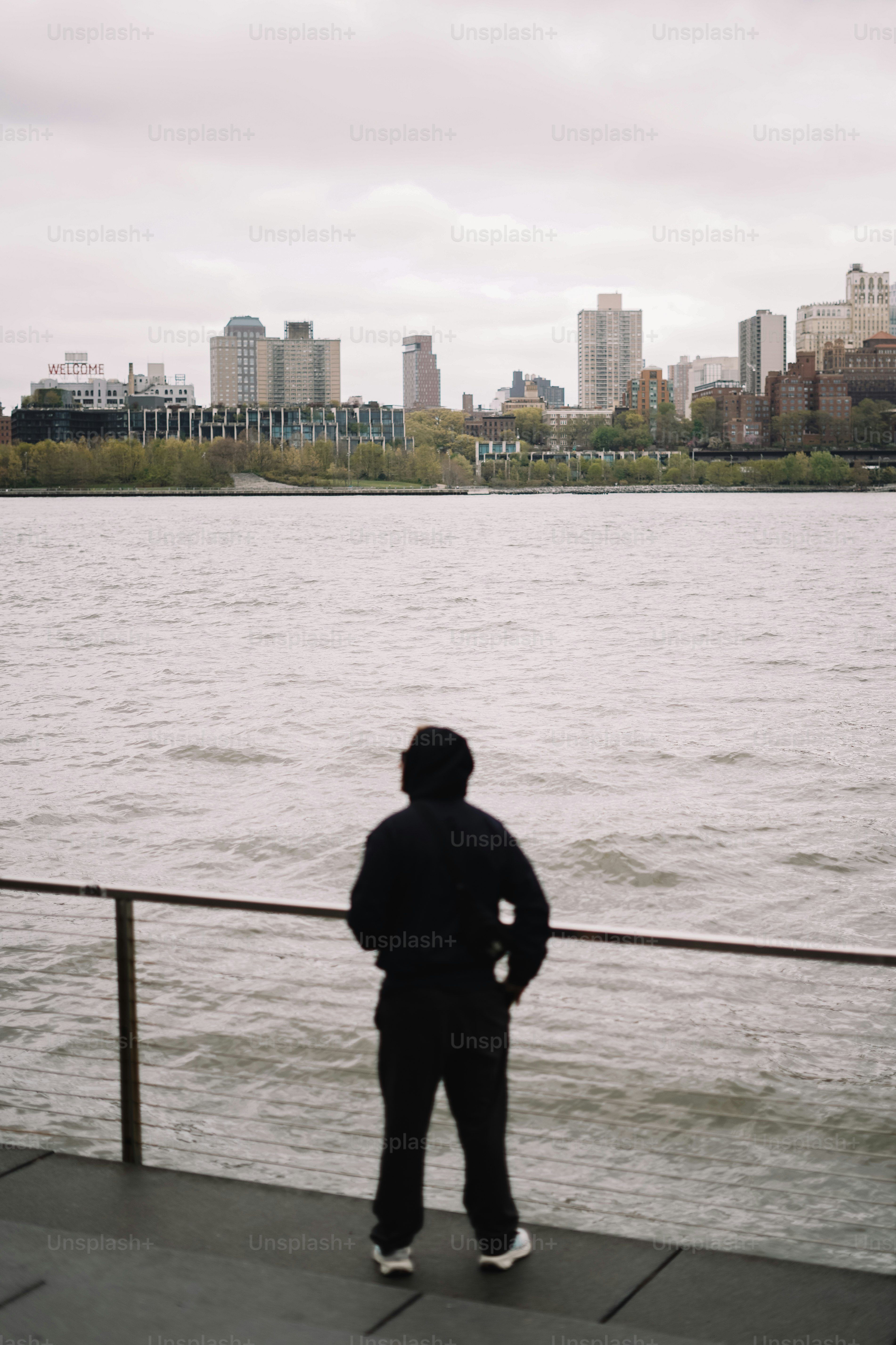 Persona che guarda lo skyline della città dall'altra parte dell'acqua