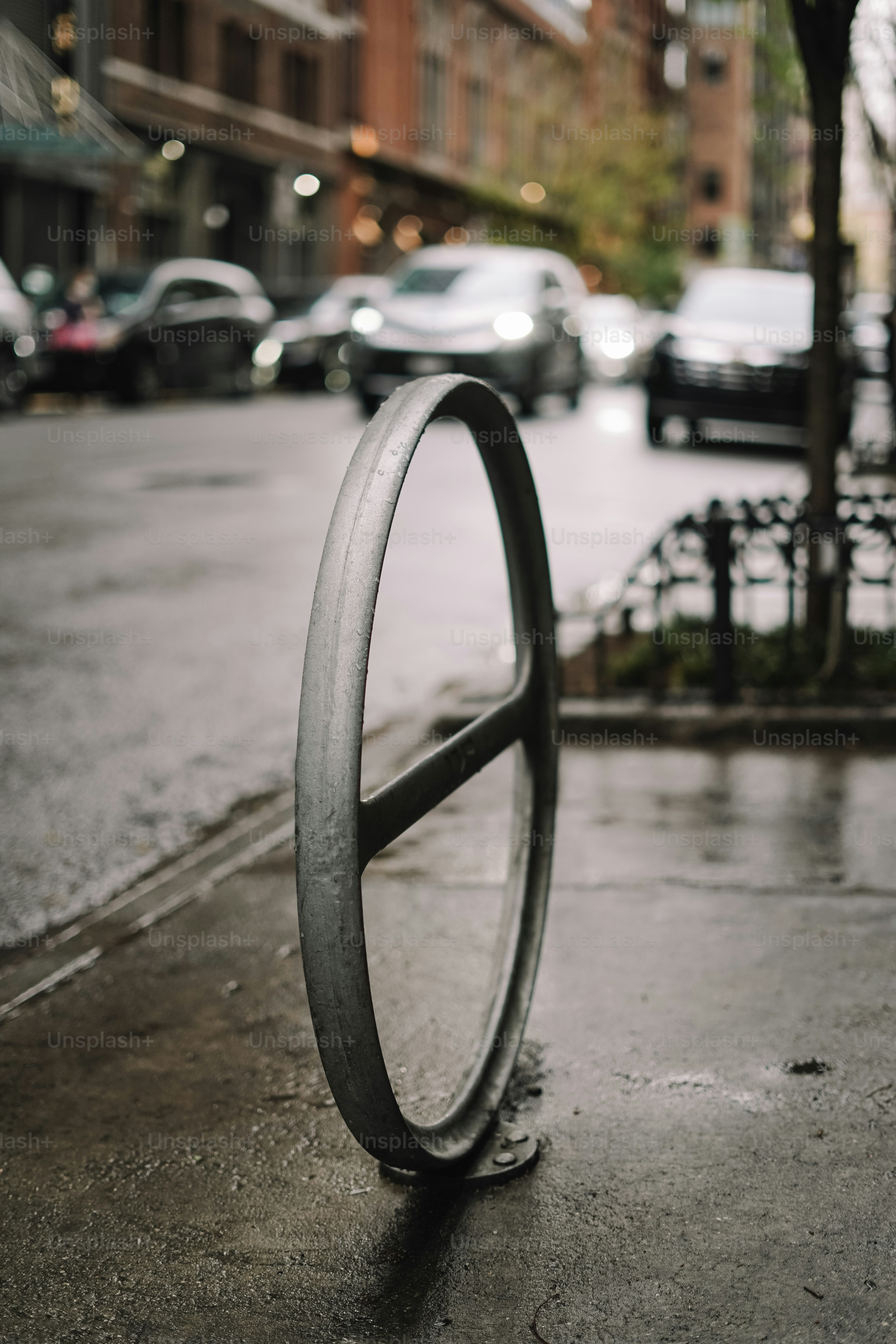 Un portabiciclette in metallo su una strada bagnata della città.
