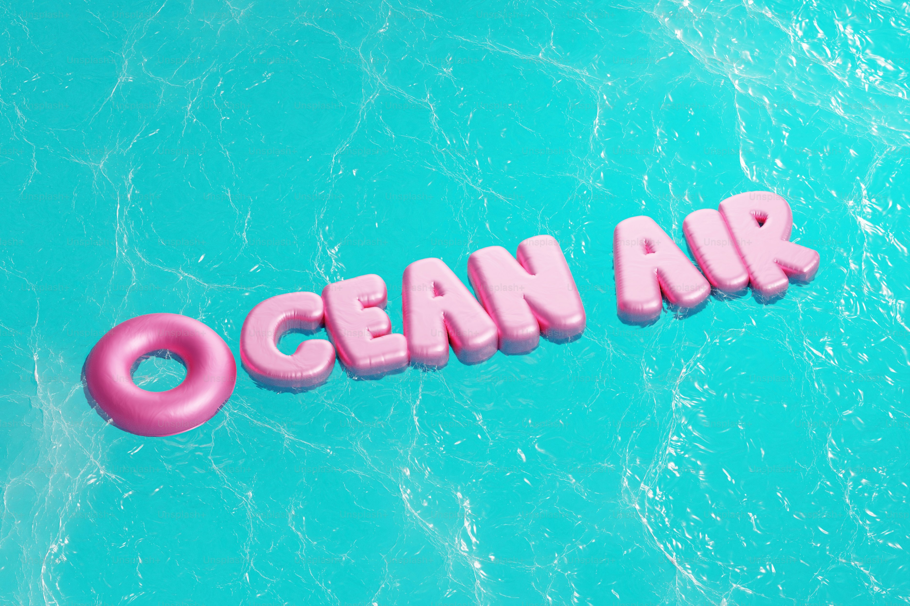 Pink letters spell ocean air on turquoise water