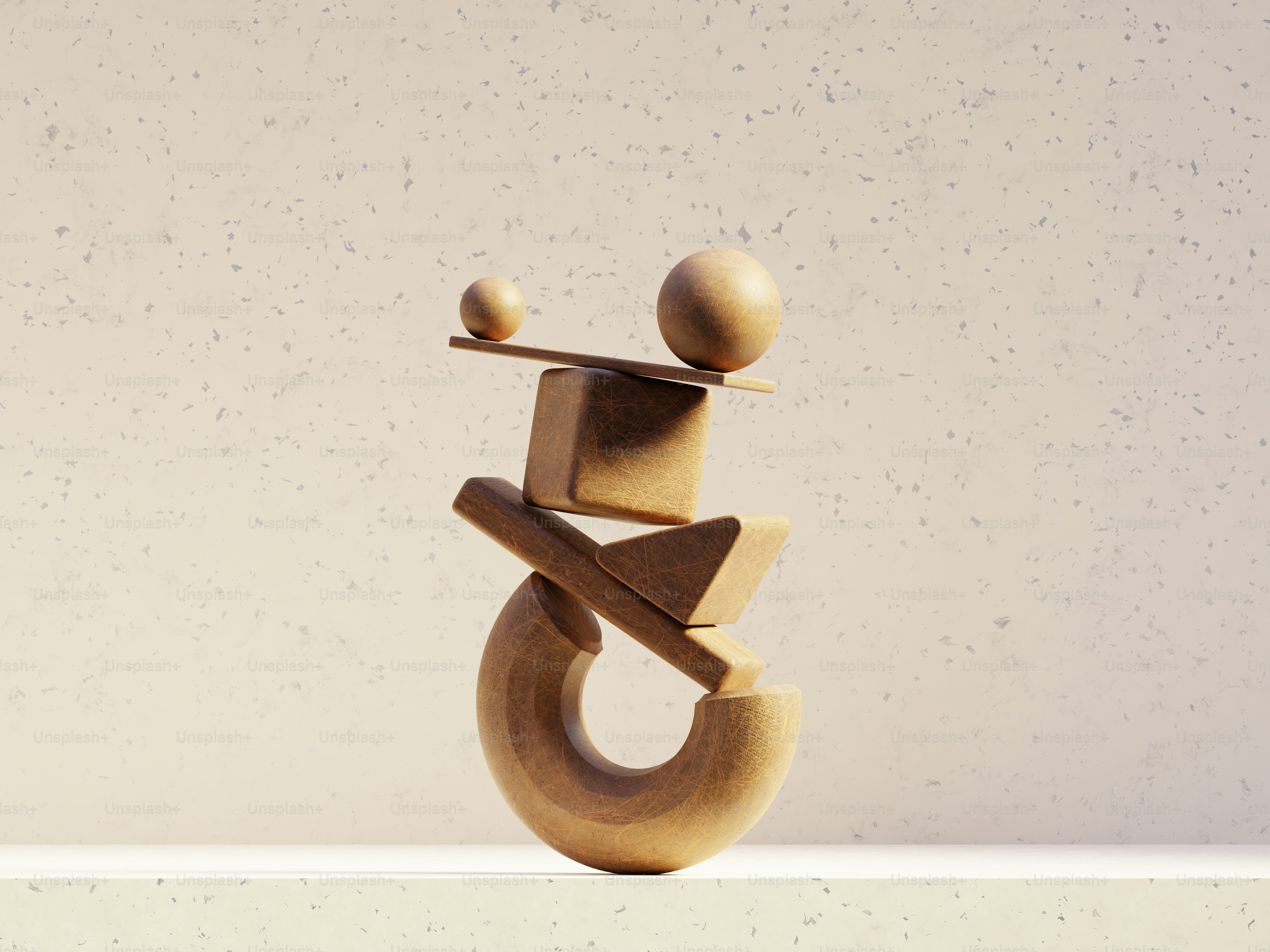 Wooden geometric shapes balanced precariously on a light surface.