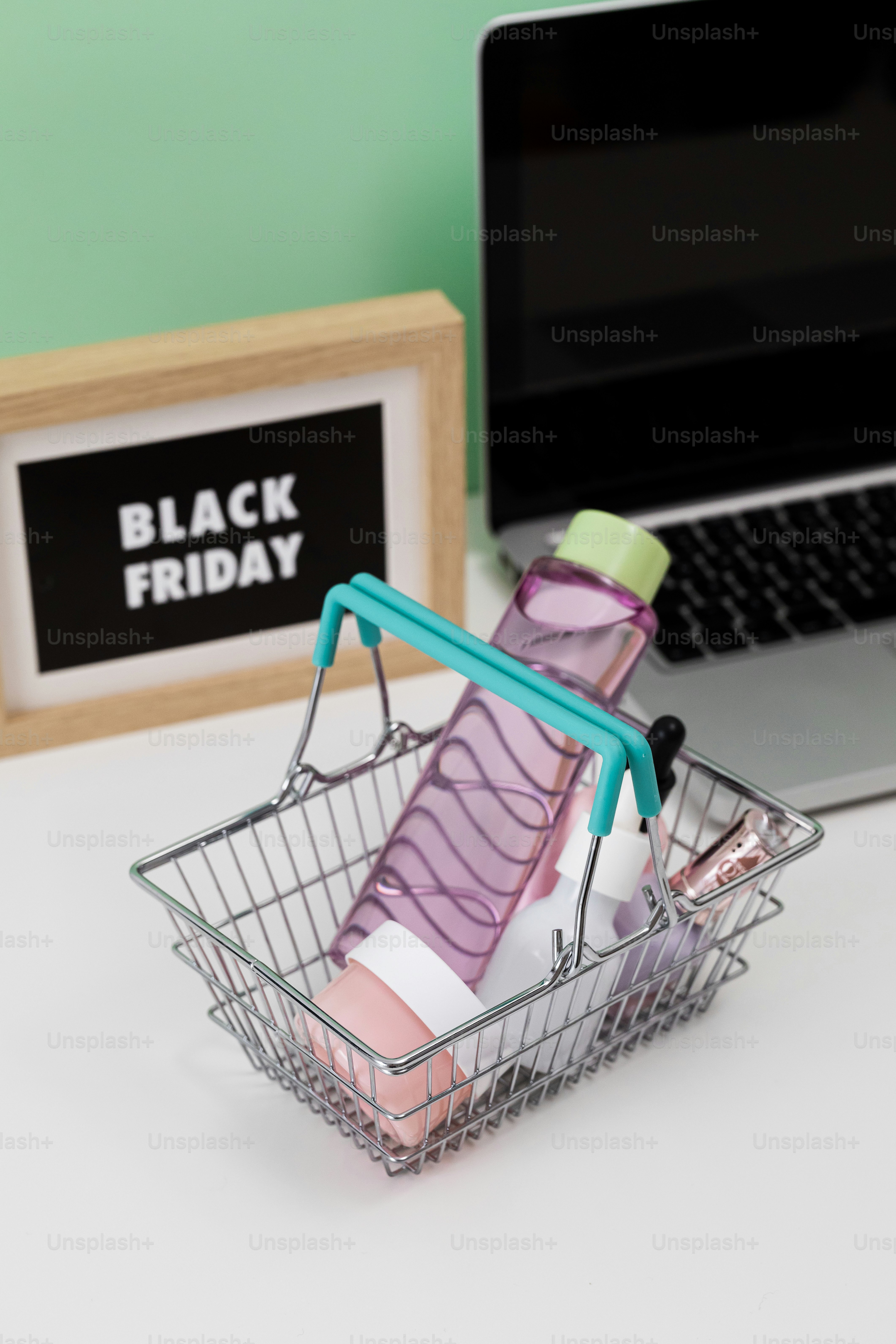 Cesta de compras com produtos de beleza e laptop.