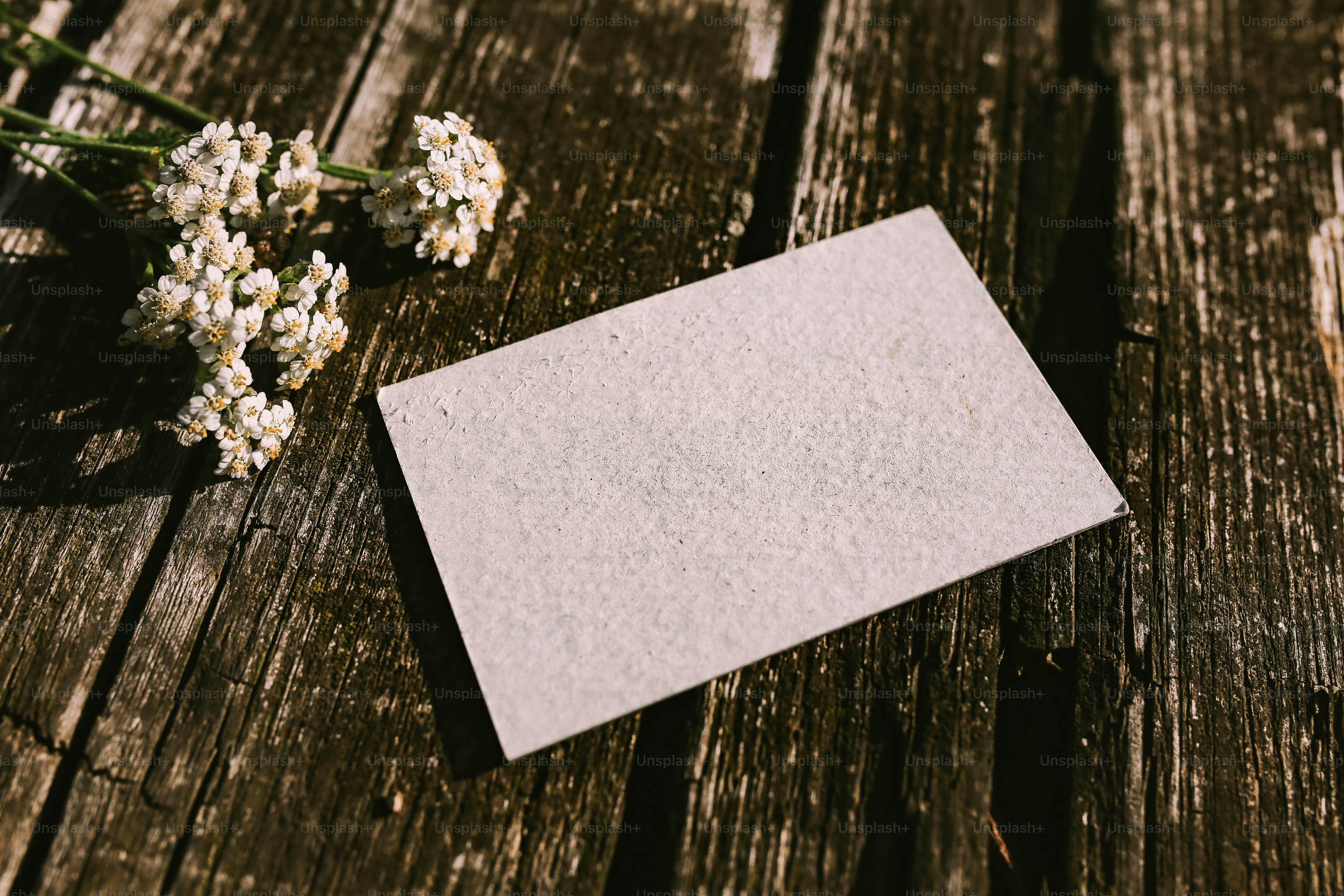 Blank card with flowers on rustic wooden table