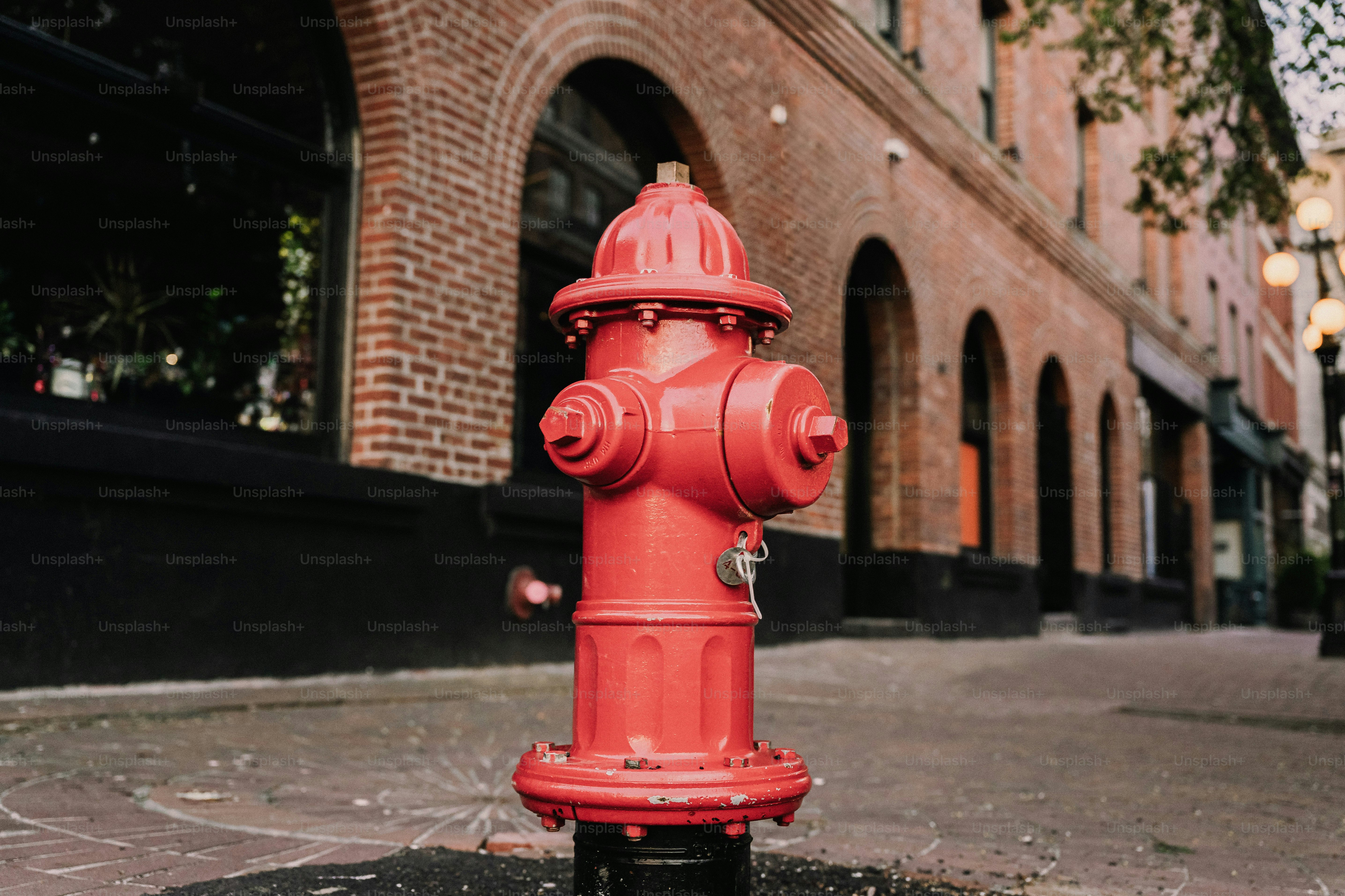 Um hidrante vermelho brilhante está na calçada da cidade