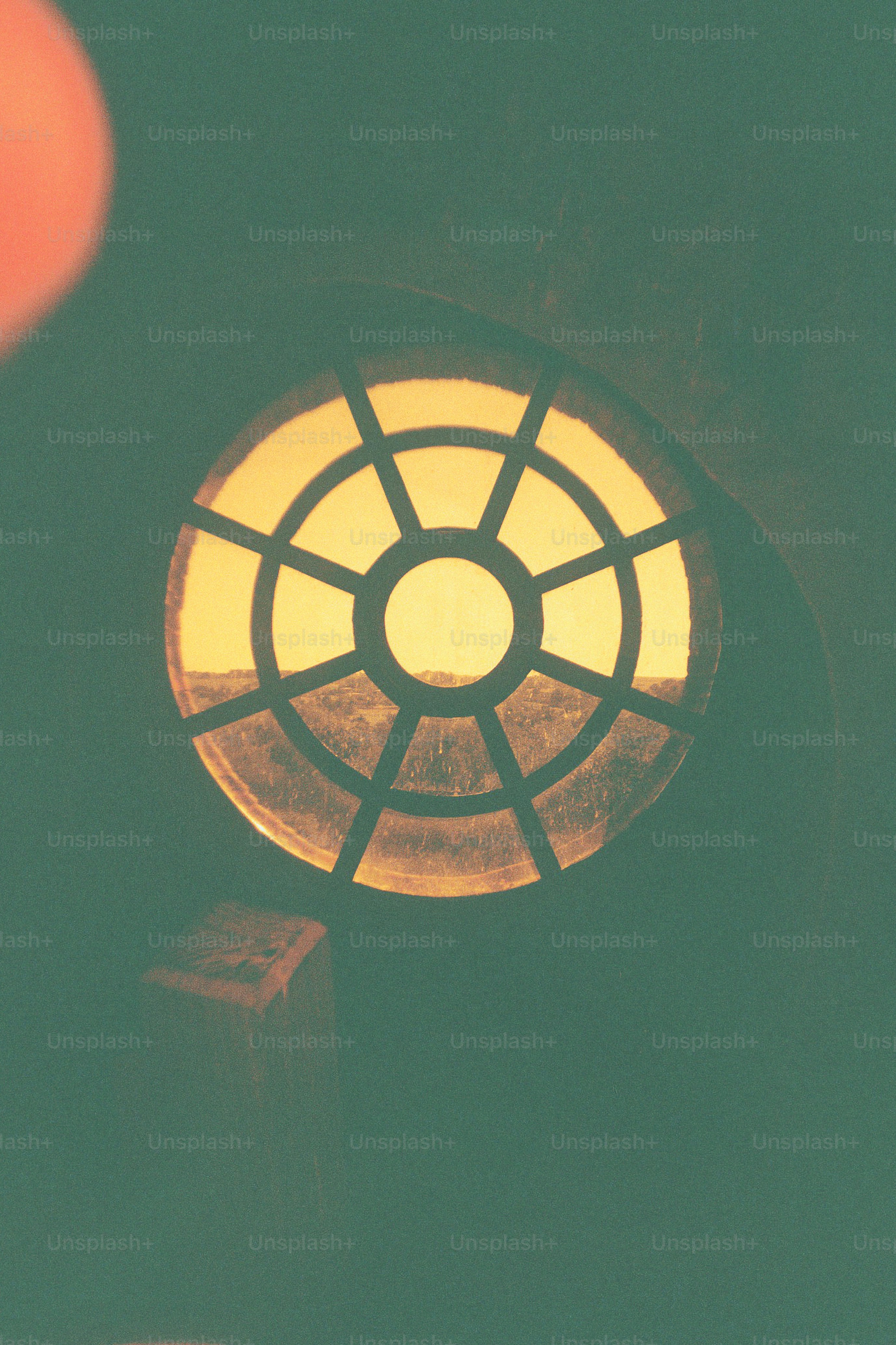 Circular window with a grid pattern at sunset.