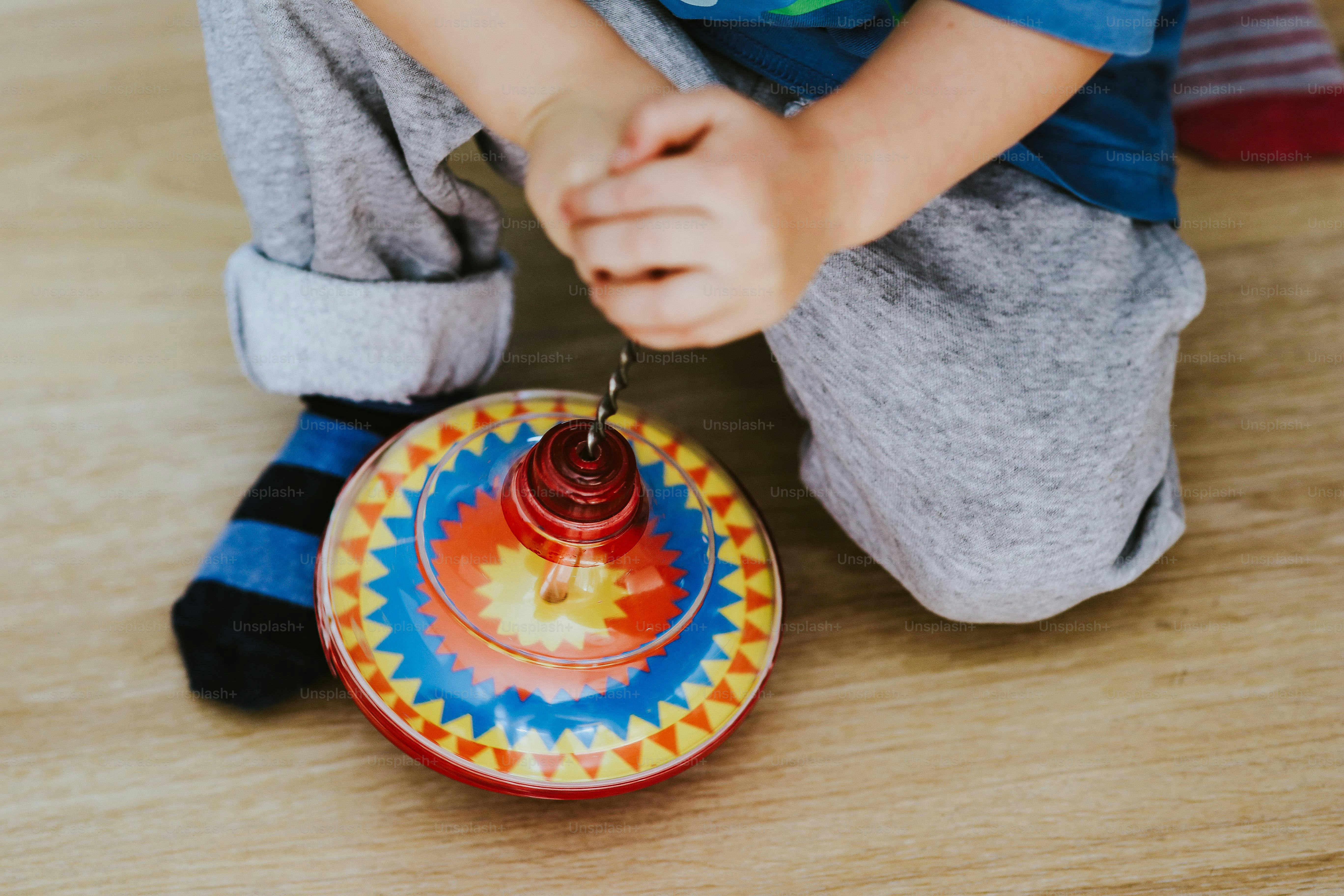 A child playing with a colorful spinning top.