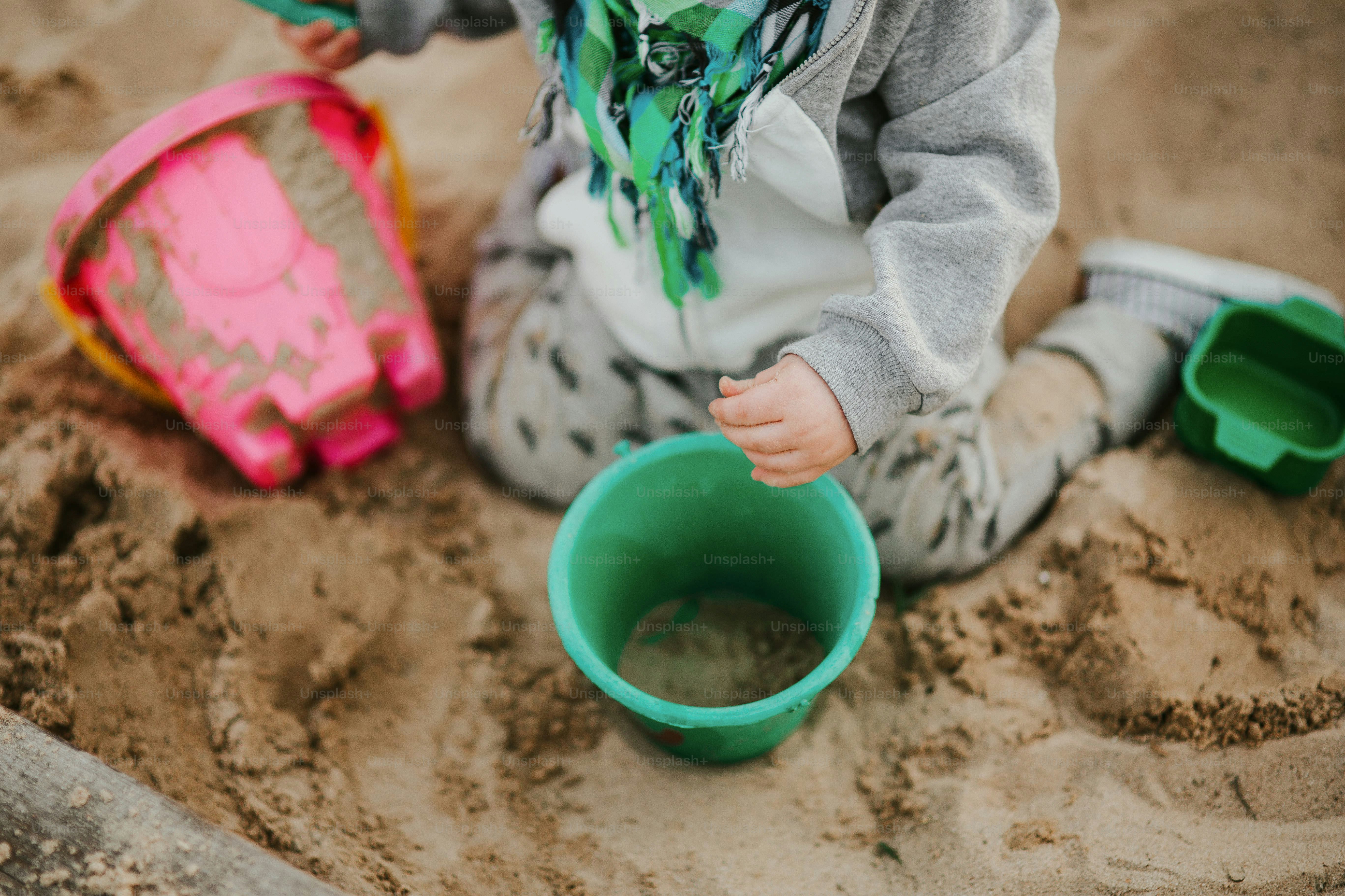 Toddler playing with simple toys in the sand