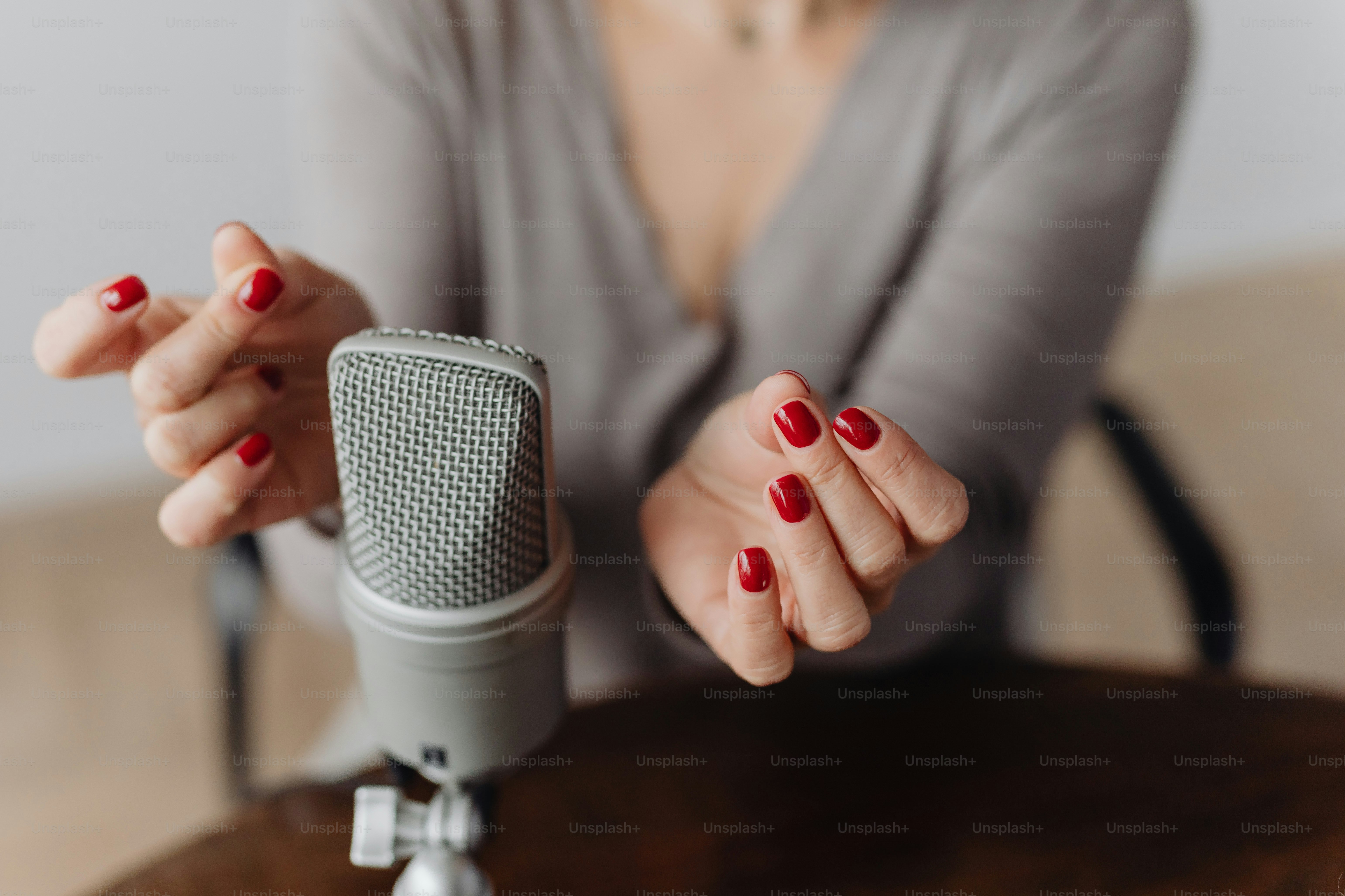 Woman with red nails gestures near microphone