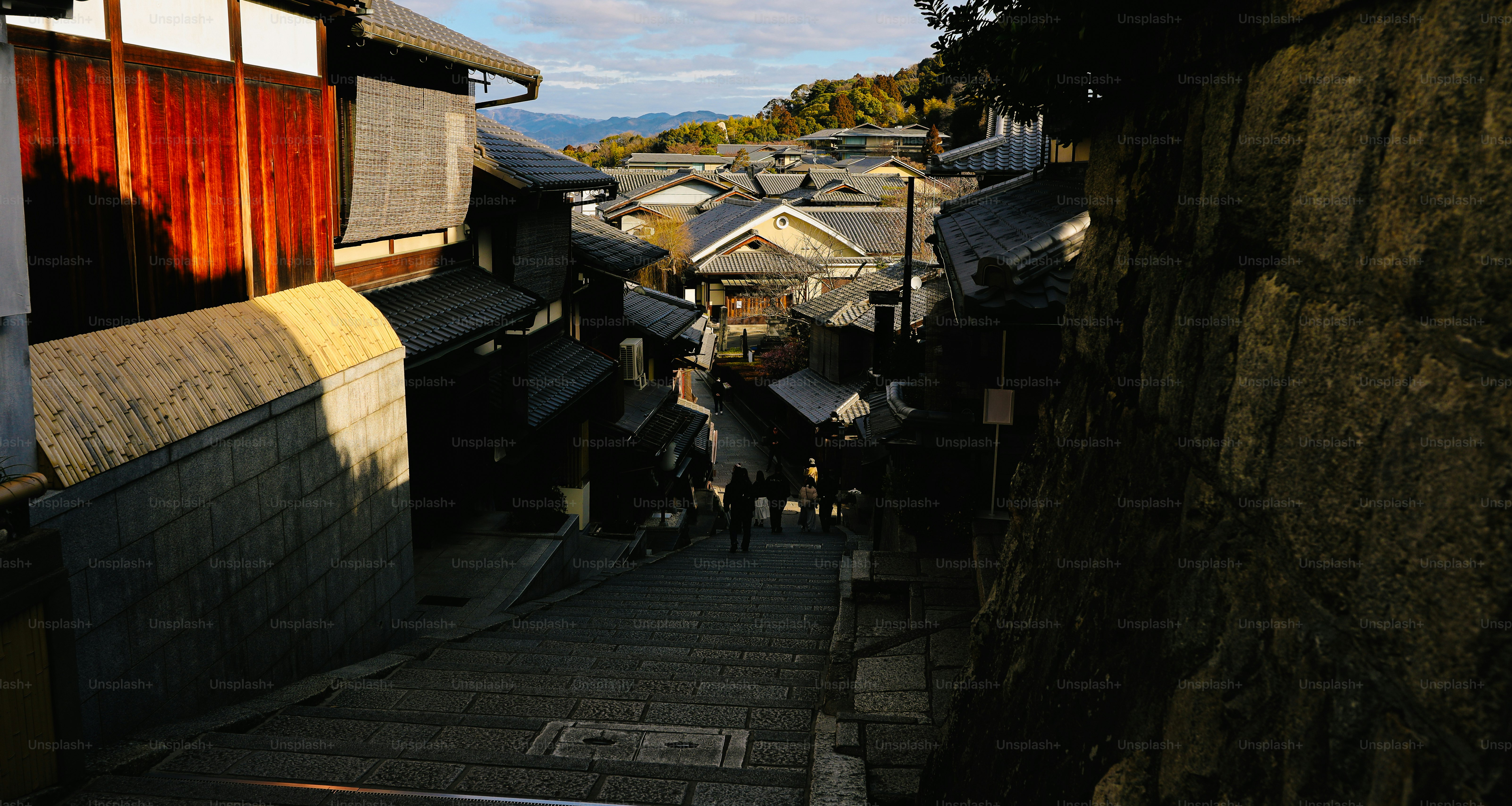 Des escaliers en pierre descendent à travers un village japonais traditionnel.