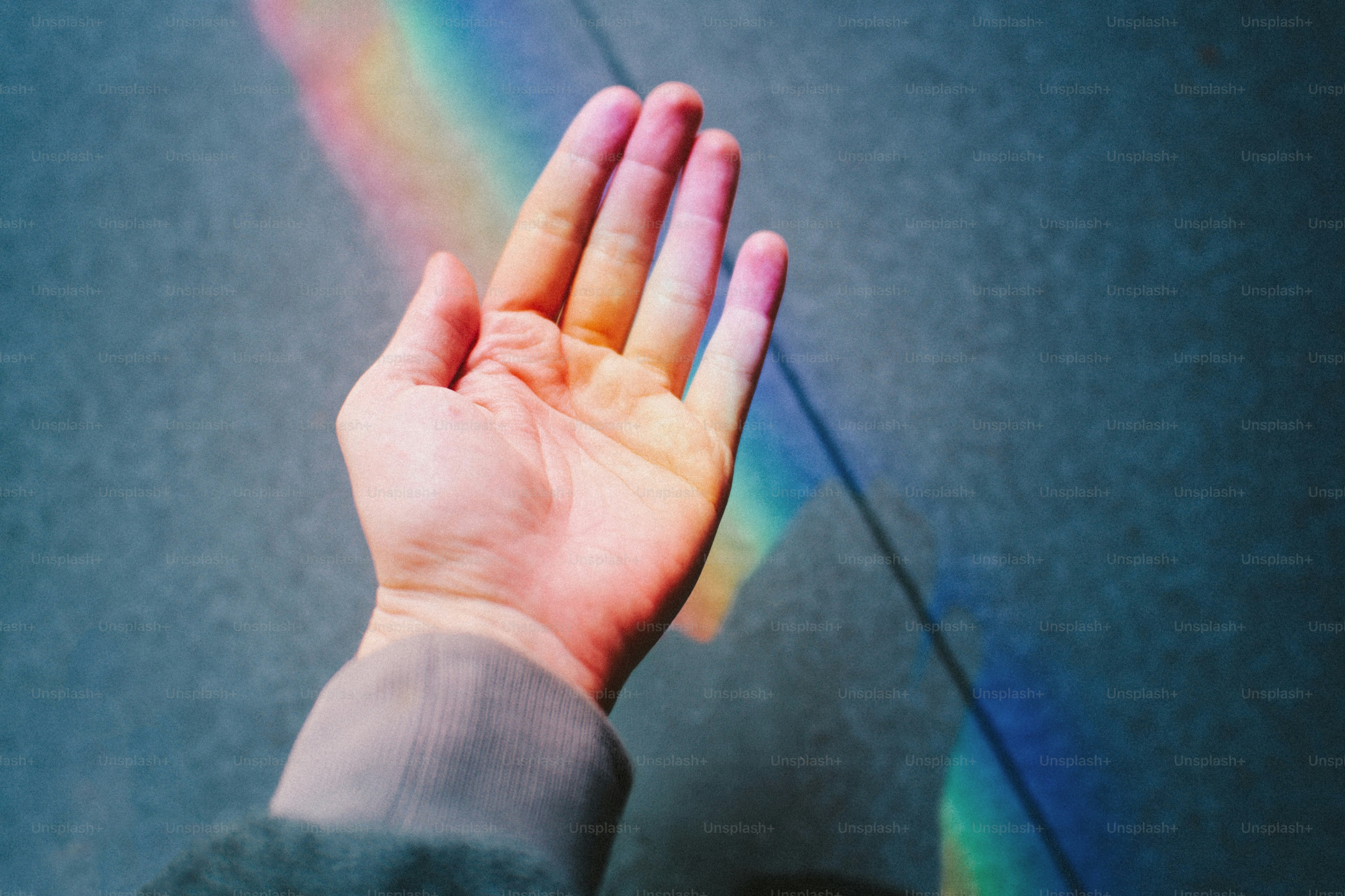 Hand catching a rainbow prism on a textured surface photo – Abstract ...