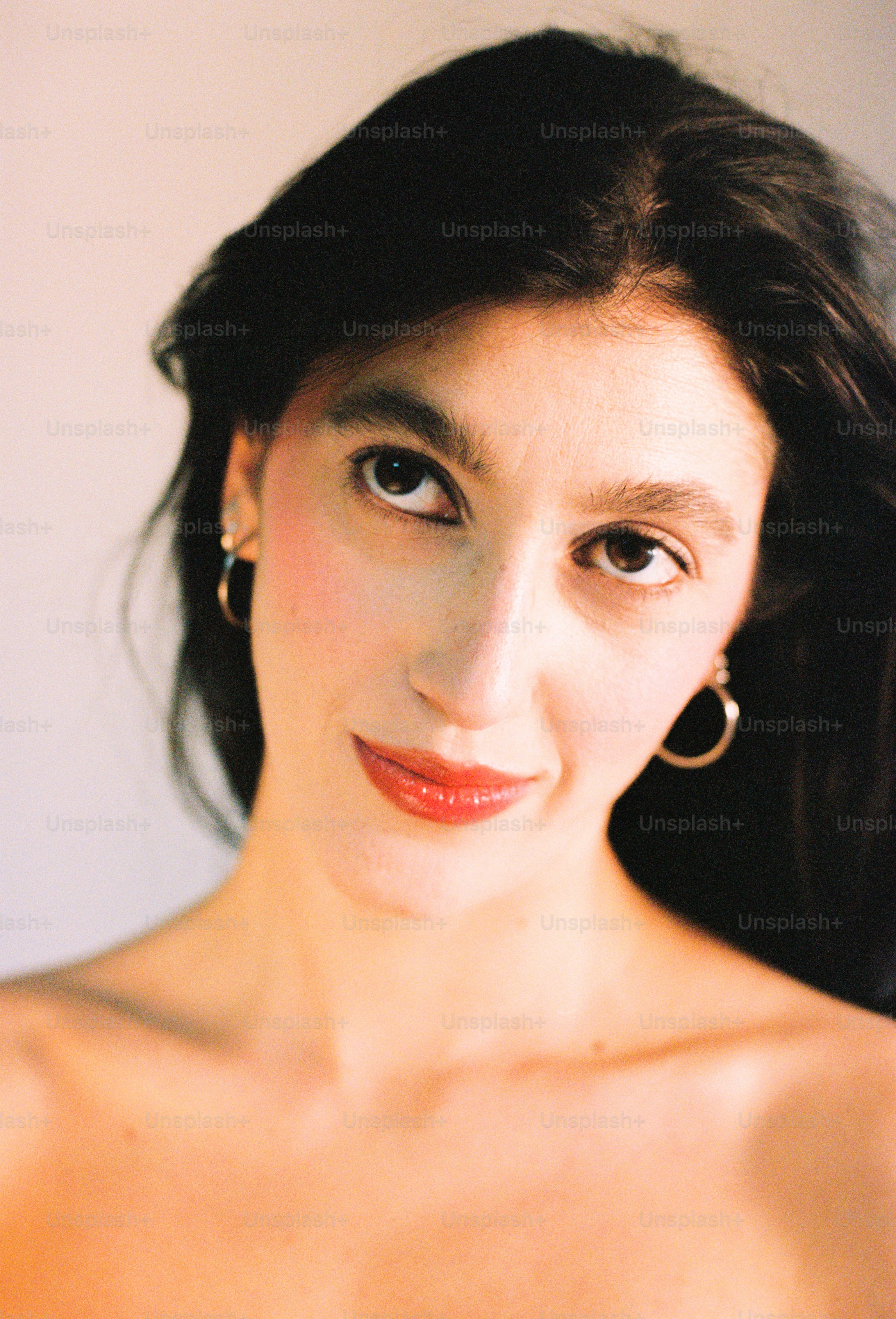 A young woman with dark hair and hoop earrings
