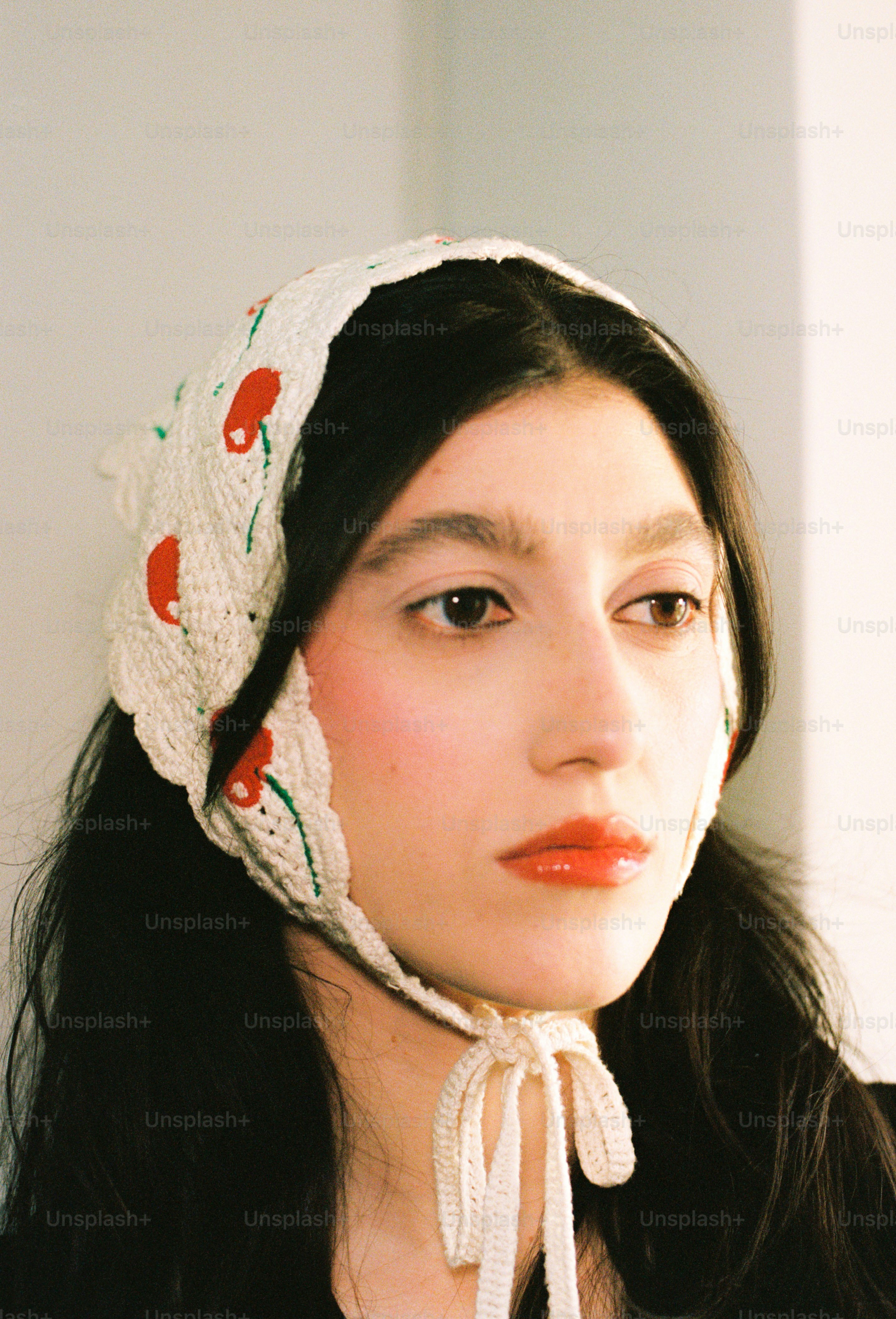 Young woman wearing a knitted headscarf with cherry pattern