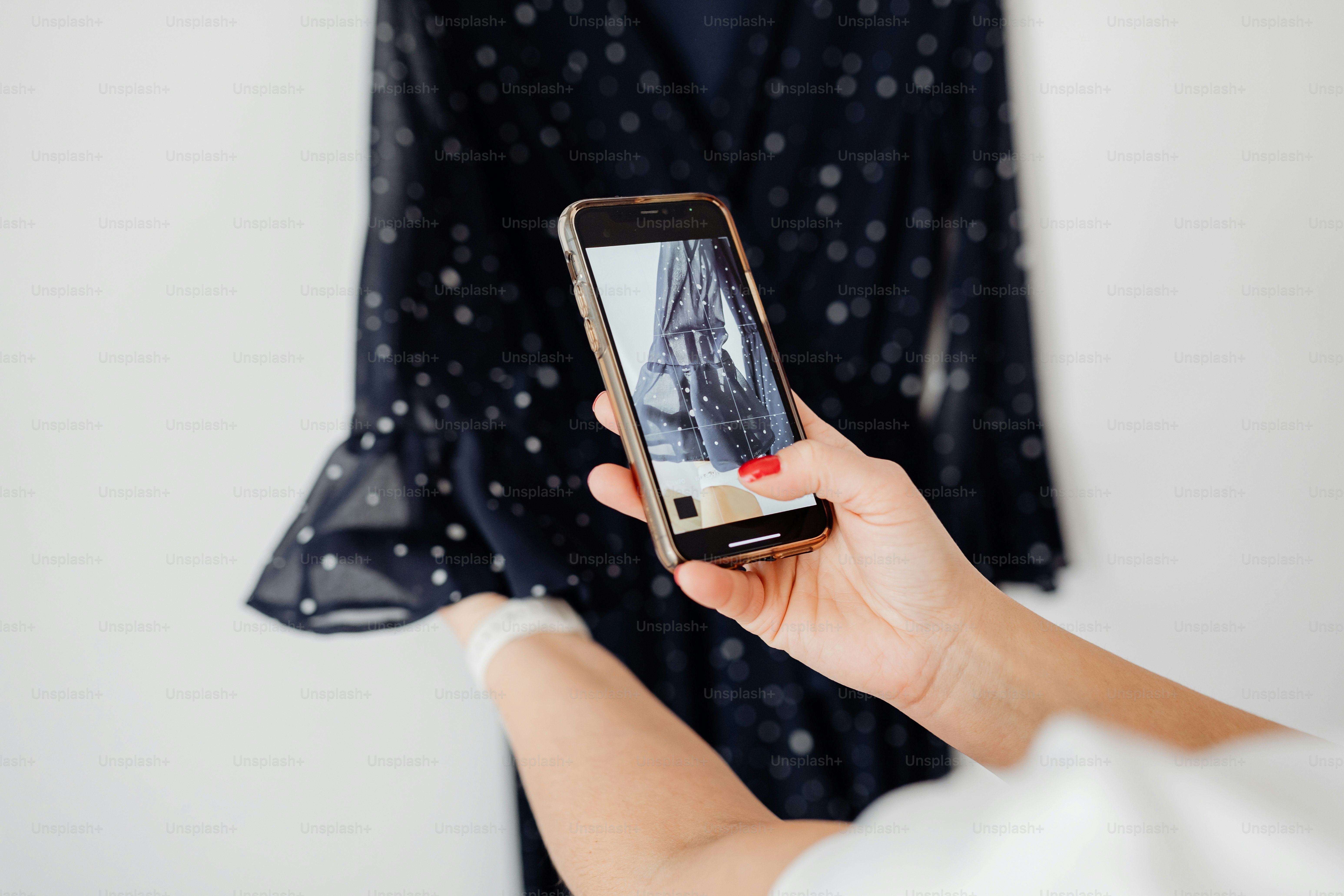 Hands holding phone taking picture of dark starry dress