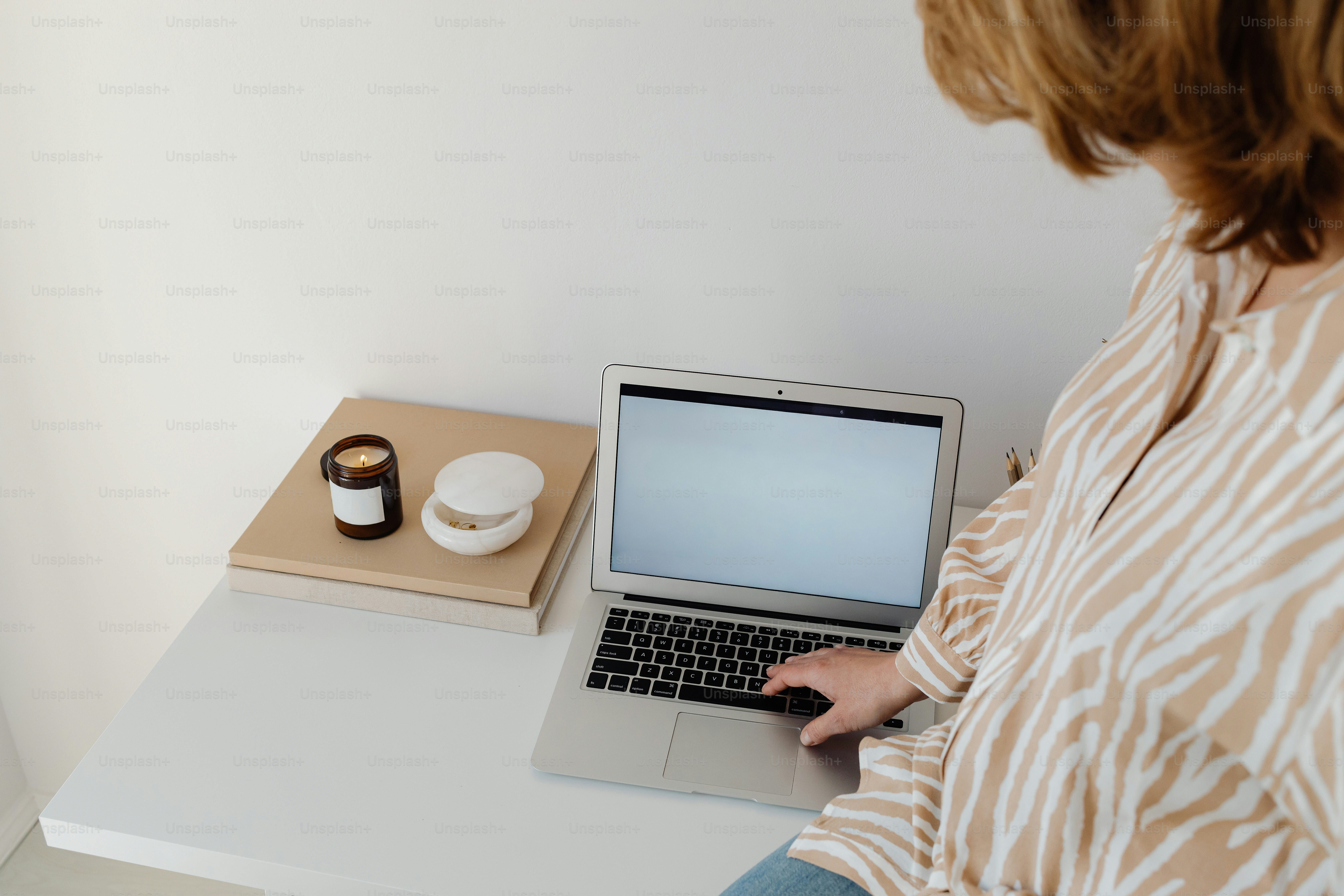 Wanita yang bekerja di laptop di meja.