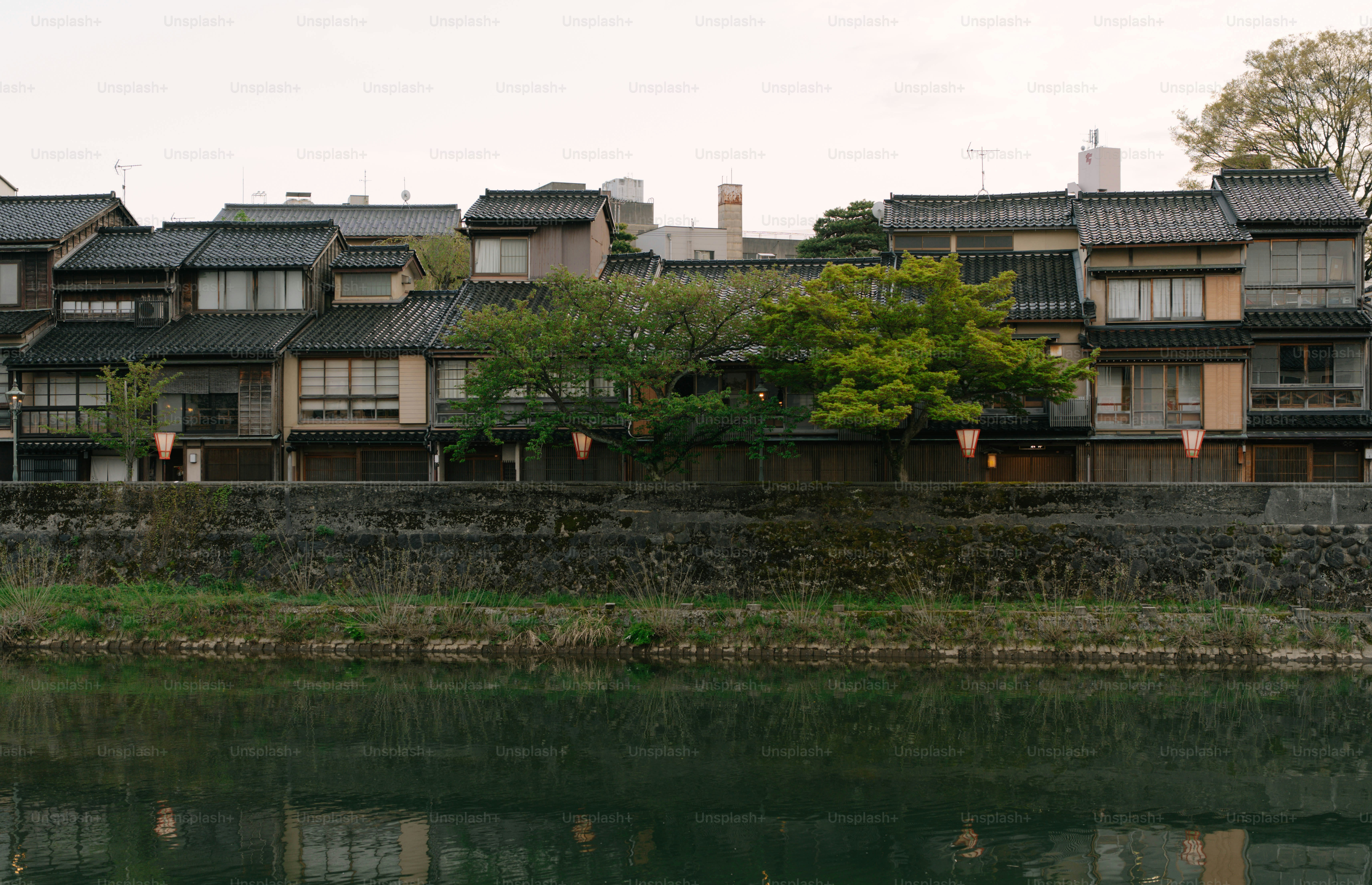 Eine Reihe traditioneller japanischer Häuser entlang eines Flusses.