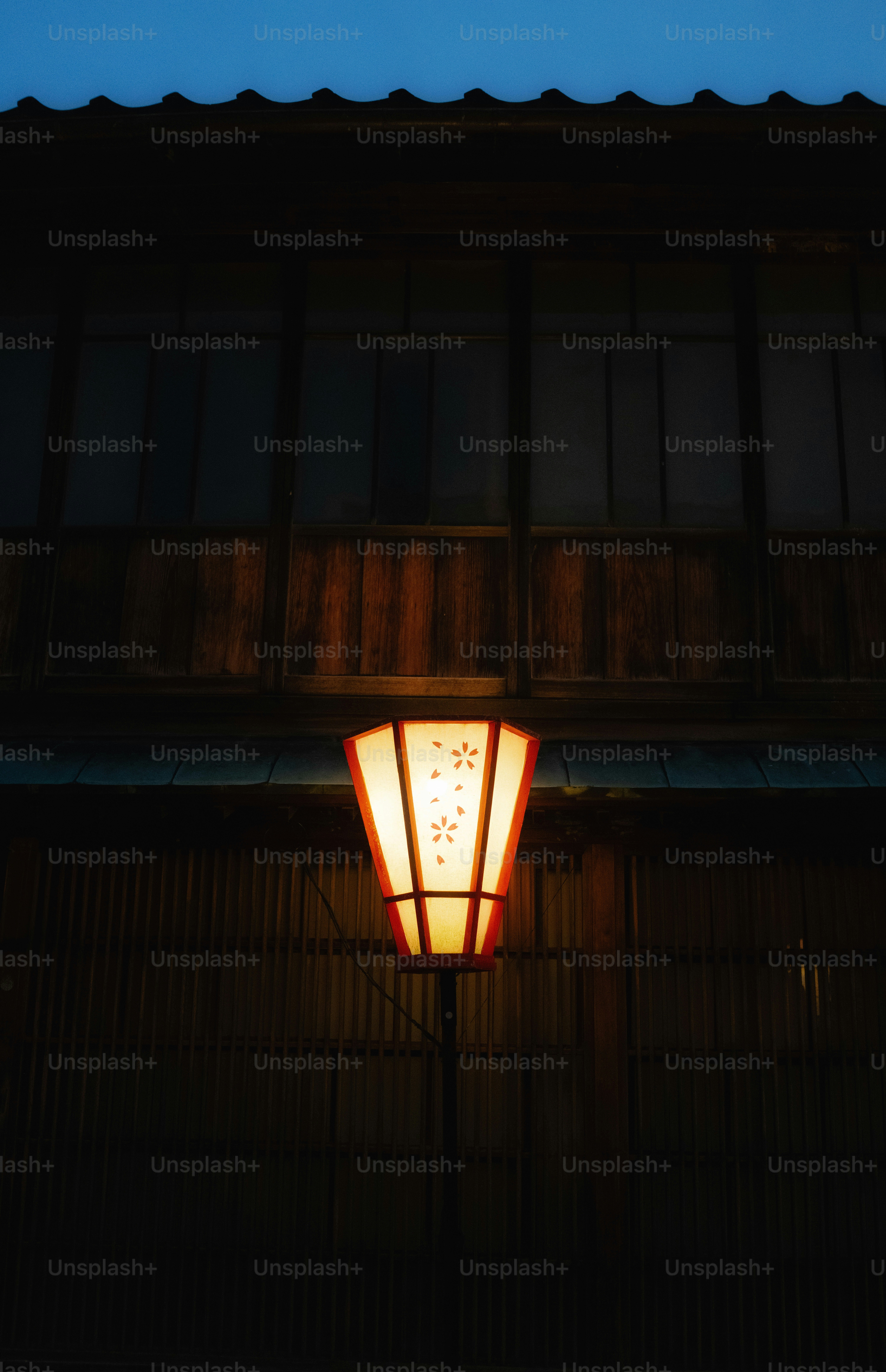 Una linterna japonesa brilla frente a un edificio de madera.