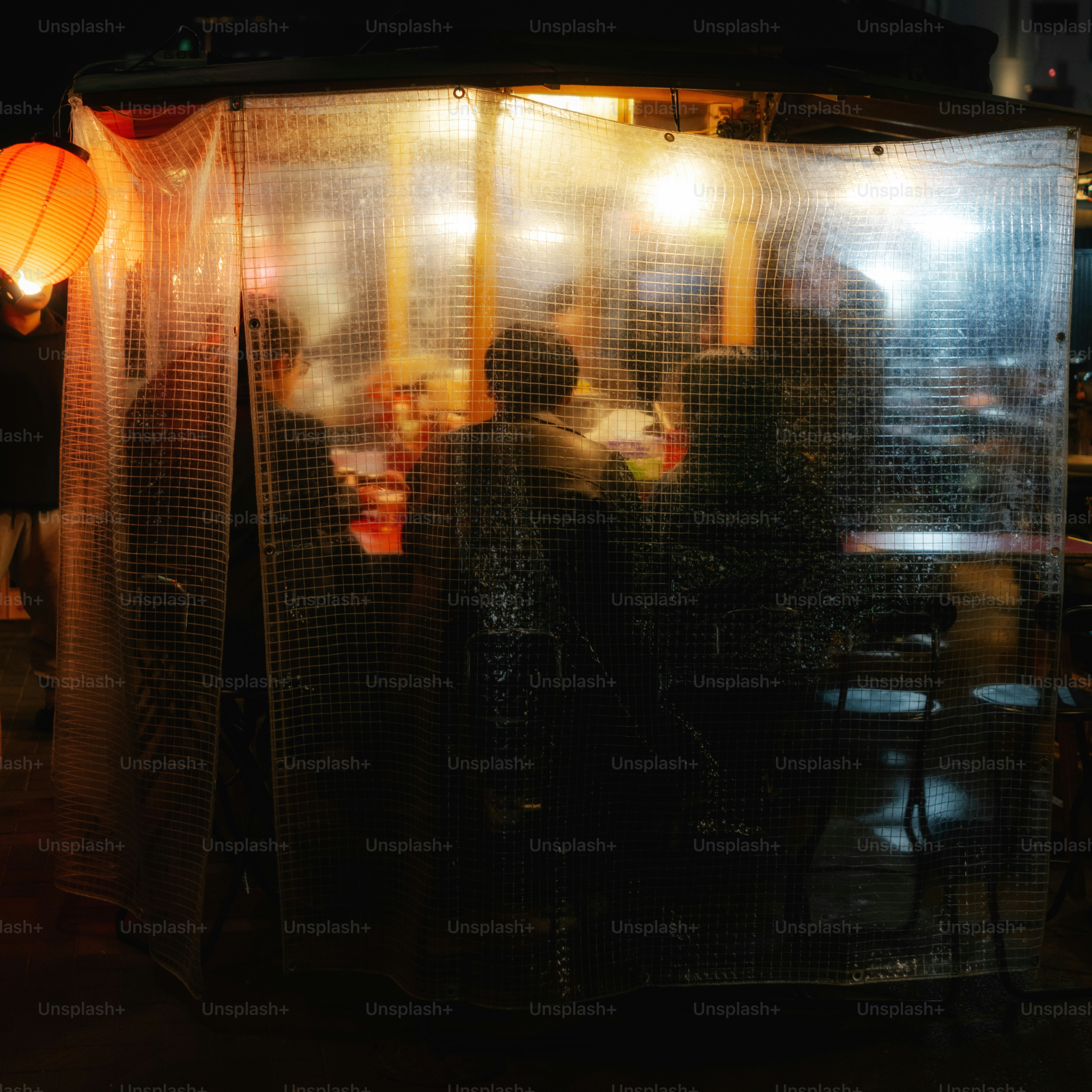 People gathered inside a brightly lit outdoor food stall.
