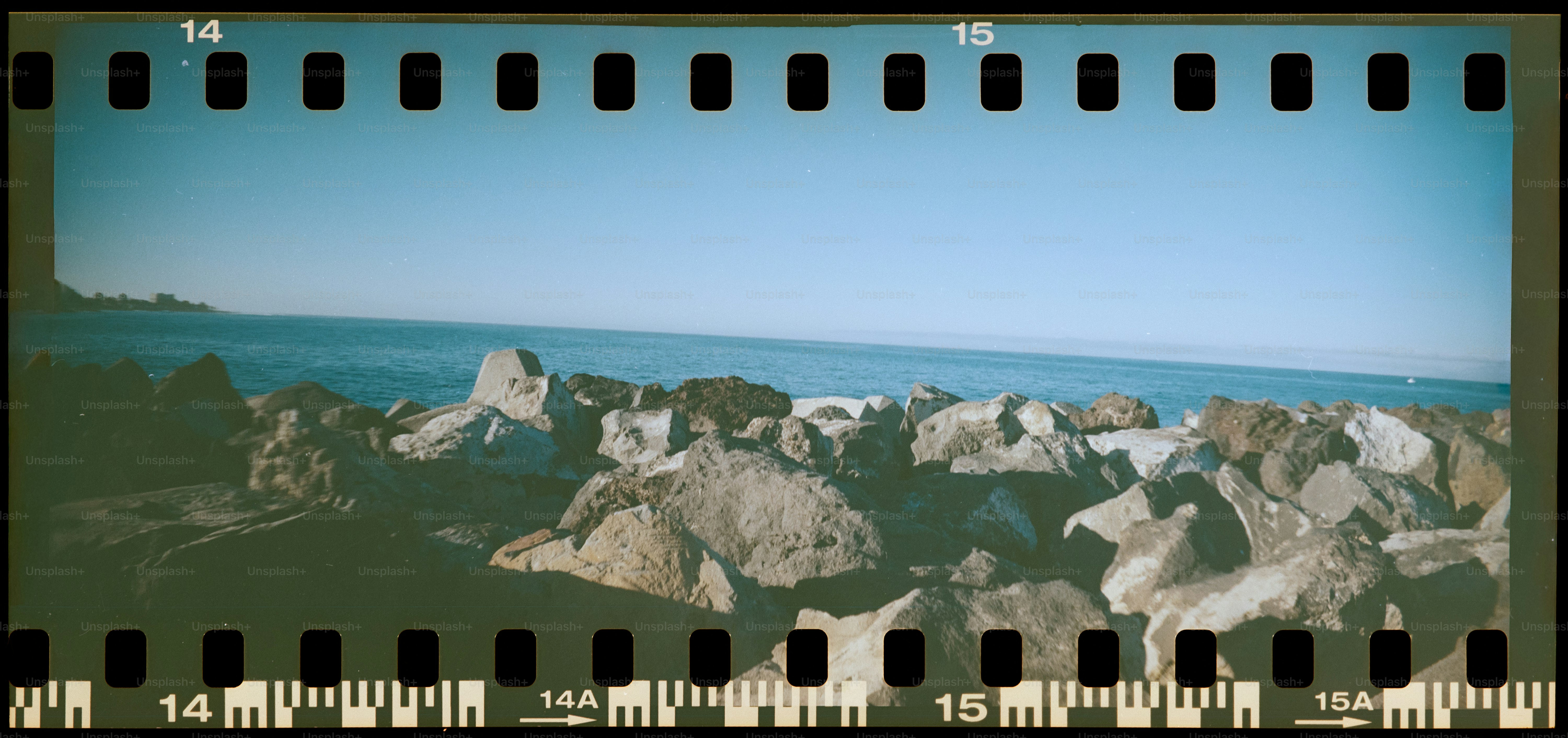 Rocky shoreline with calm blue ocean and clear sky