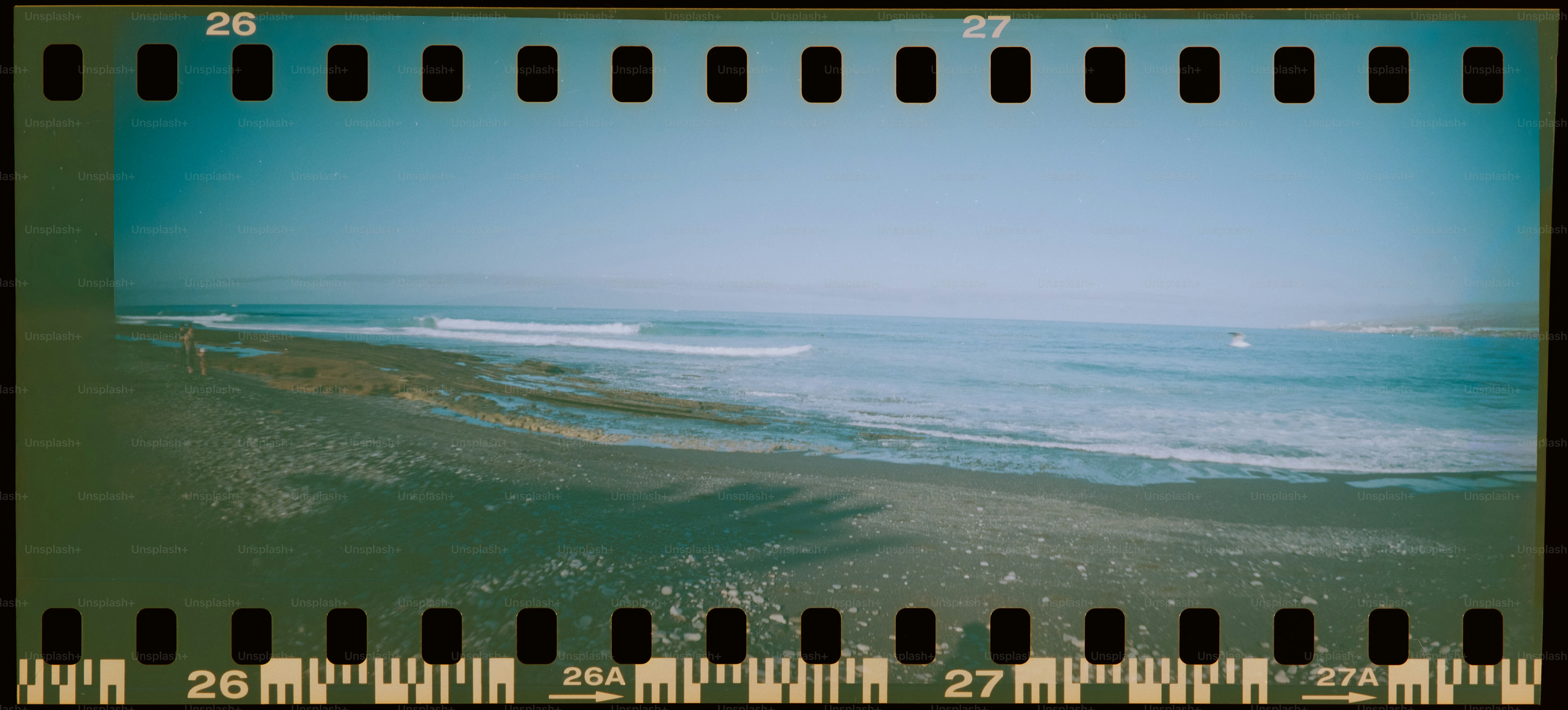 Waves rolling onto a rocky shore under a clear sky