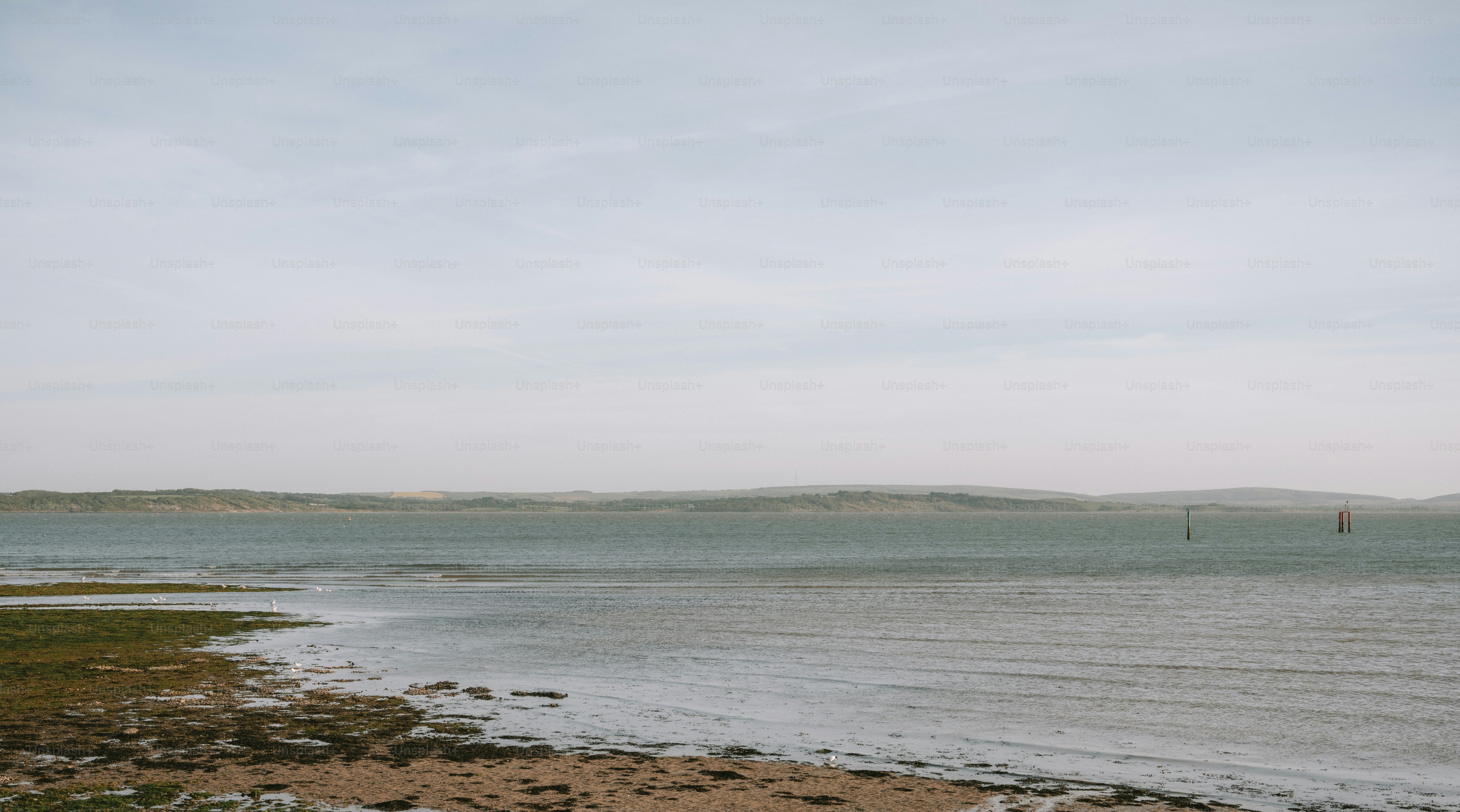 Calm ocean waves gently lap a rocky shore.