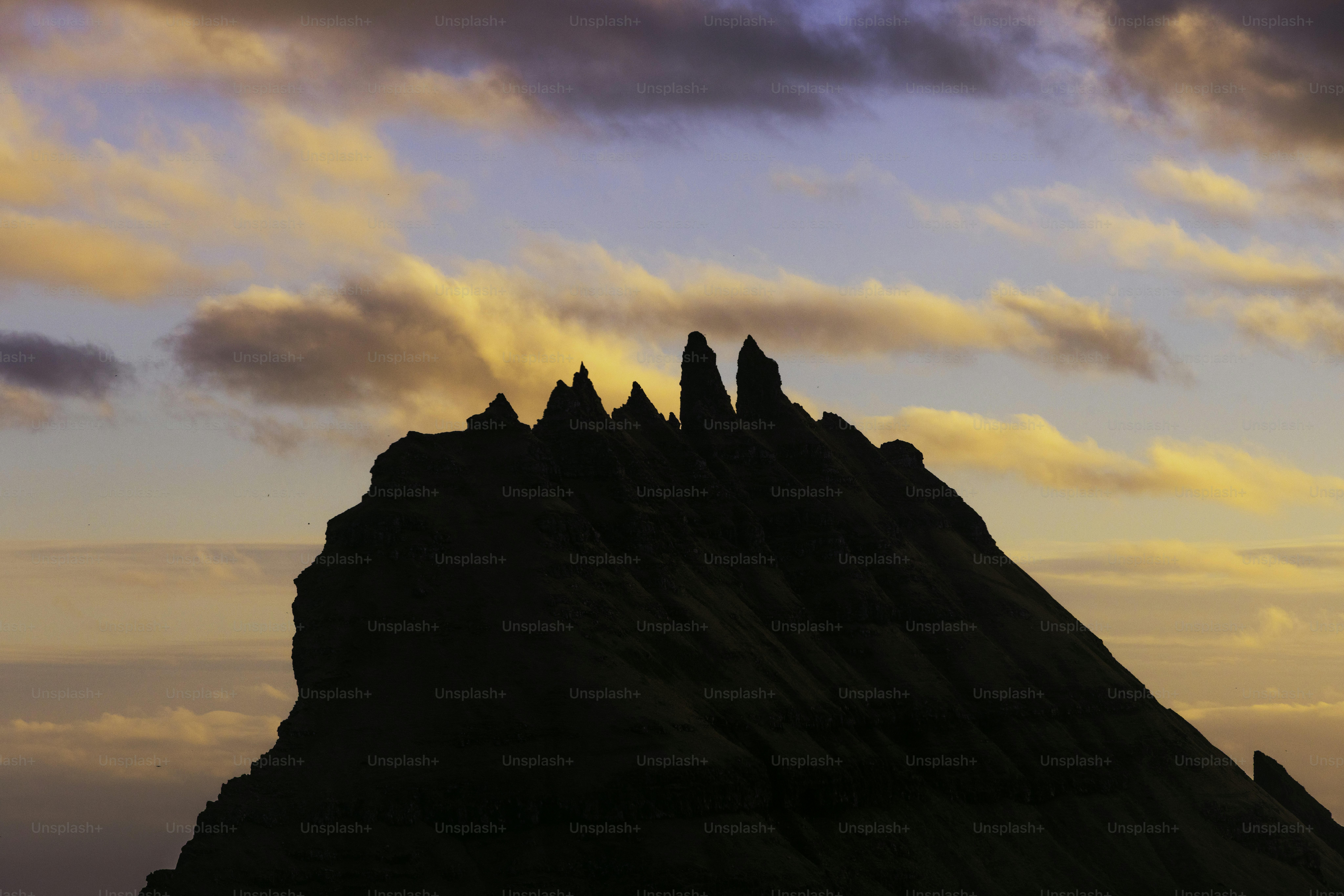 Jagged mountain peak silhouetted against a colorful sunset sky