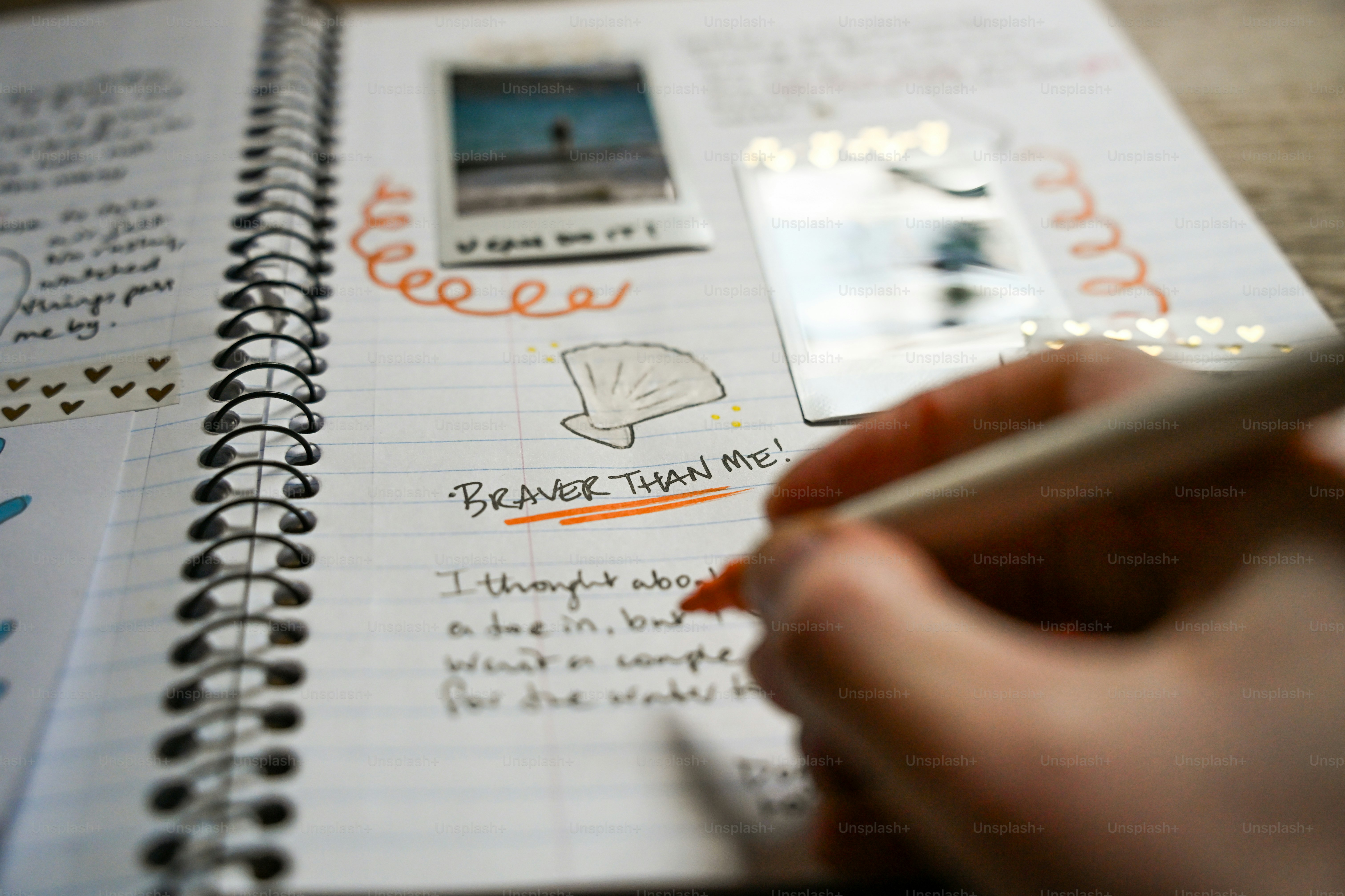 Hand writing in a journal with photos and photos