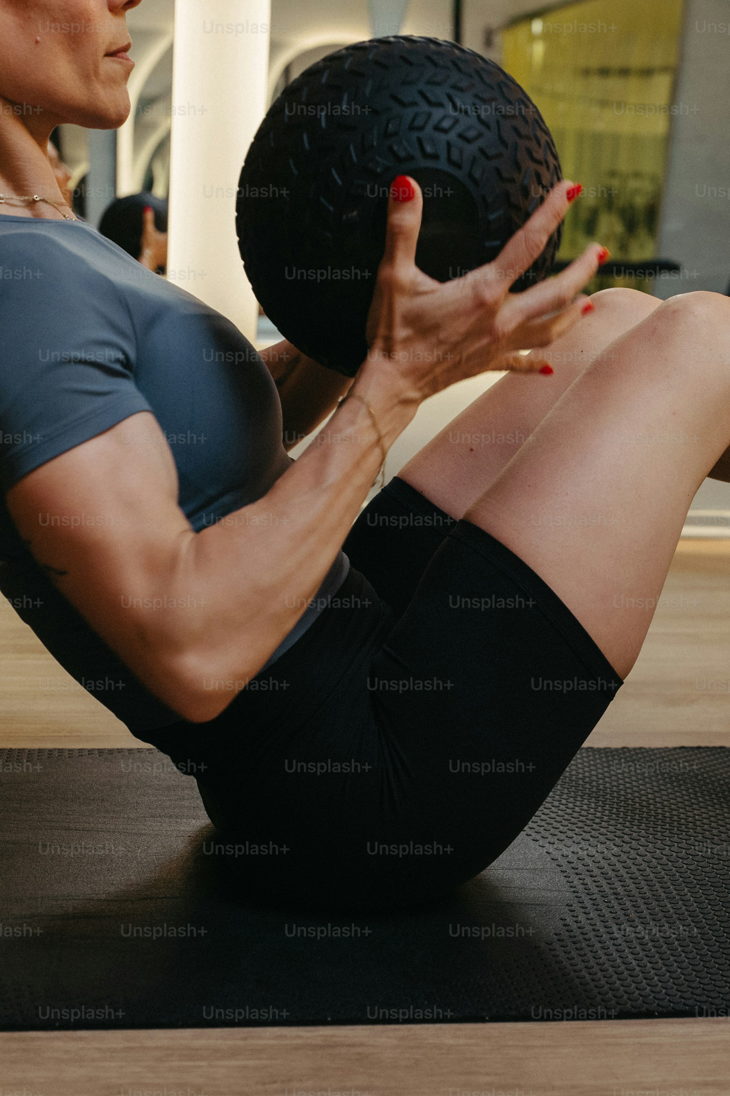Frau hält während eines Trainings einen Medizinball.