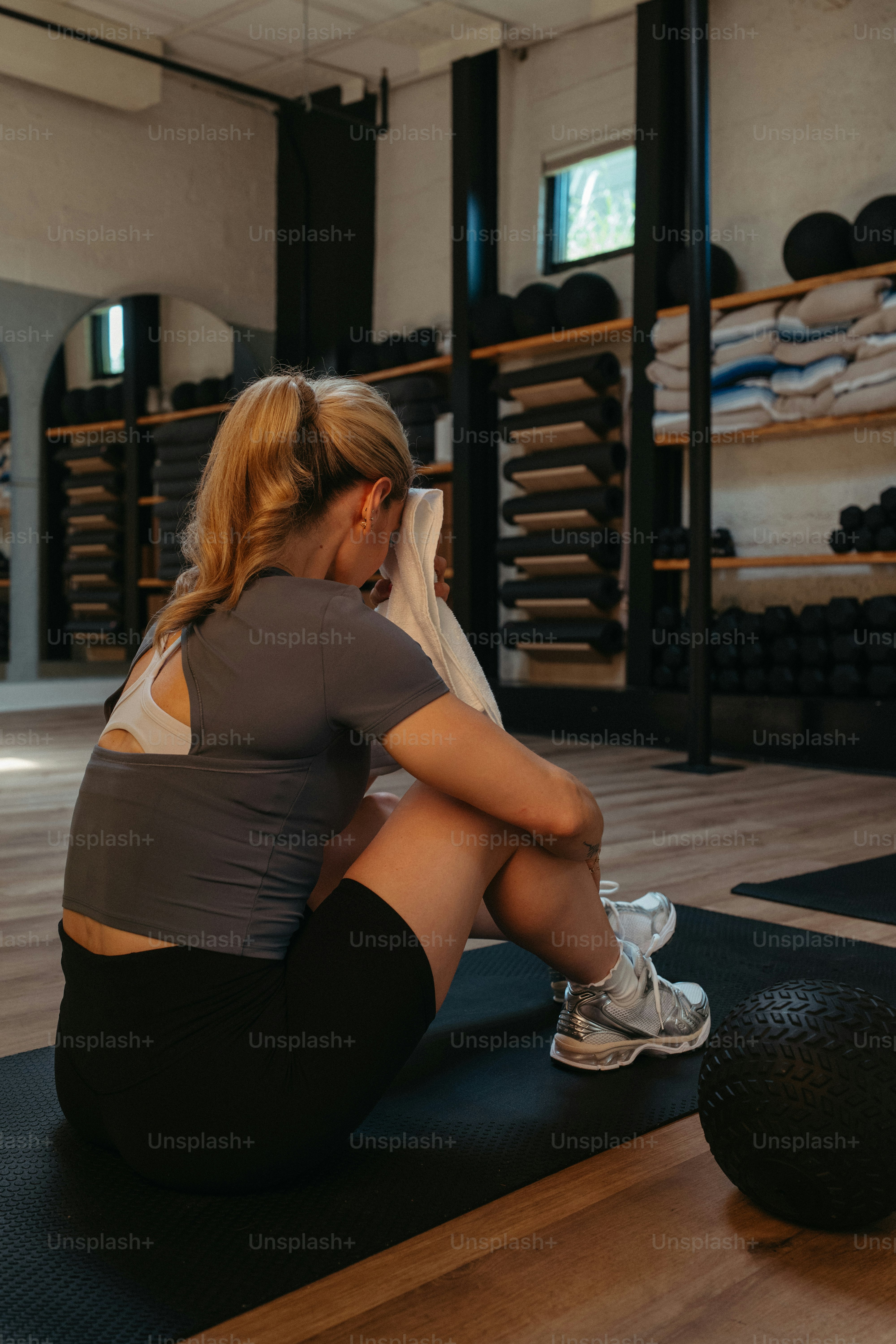 Frau, die nach dem Training mit einem Handtuch den Schweiß abwischt