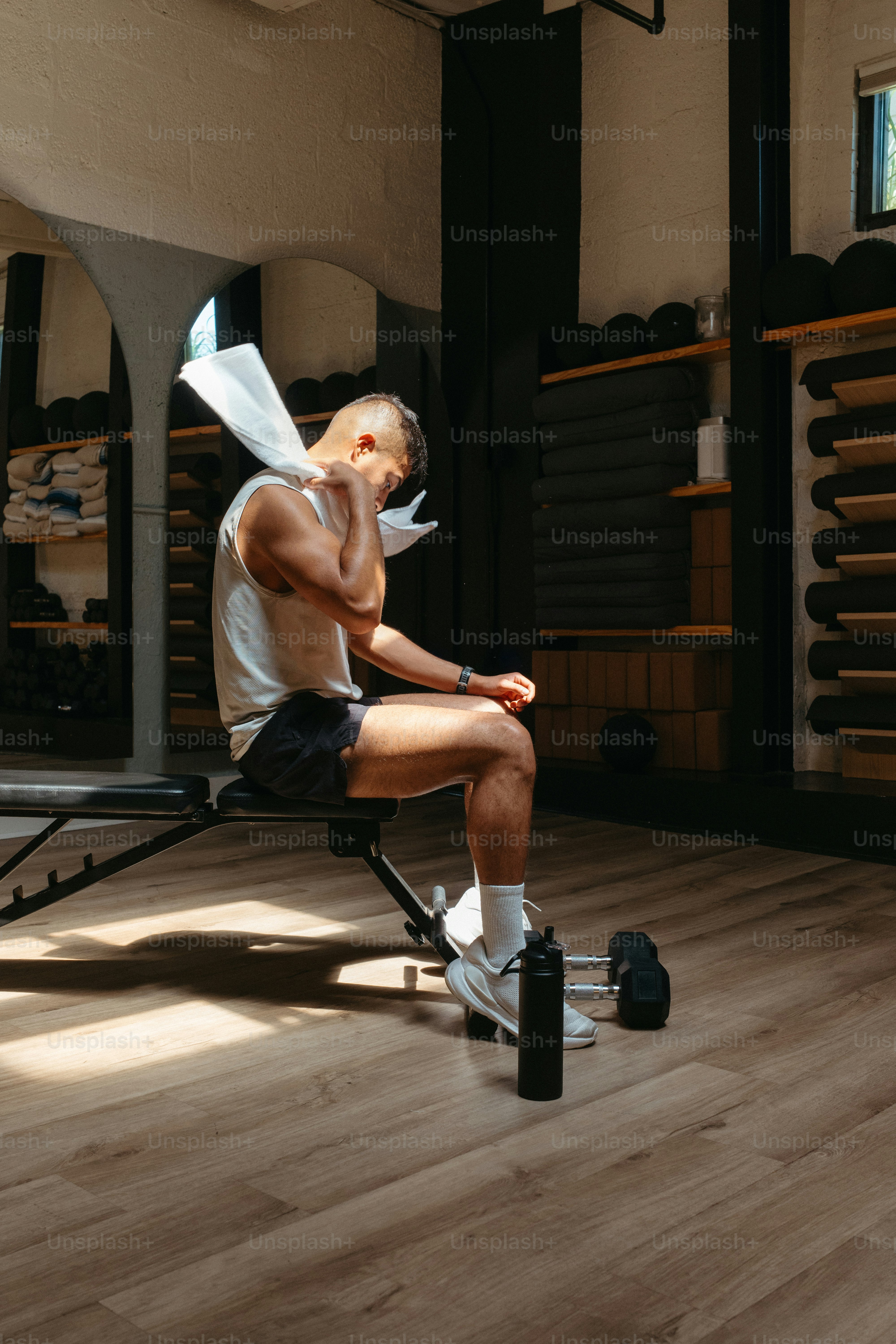 Mann, der nach dem Training mit einem Handtuch Schweiß abwischt