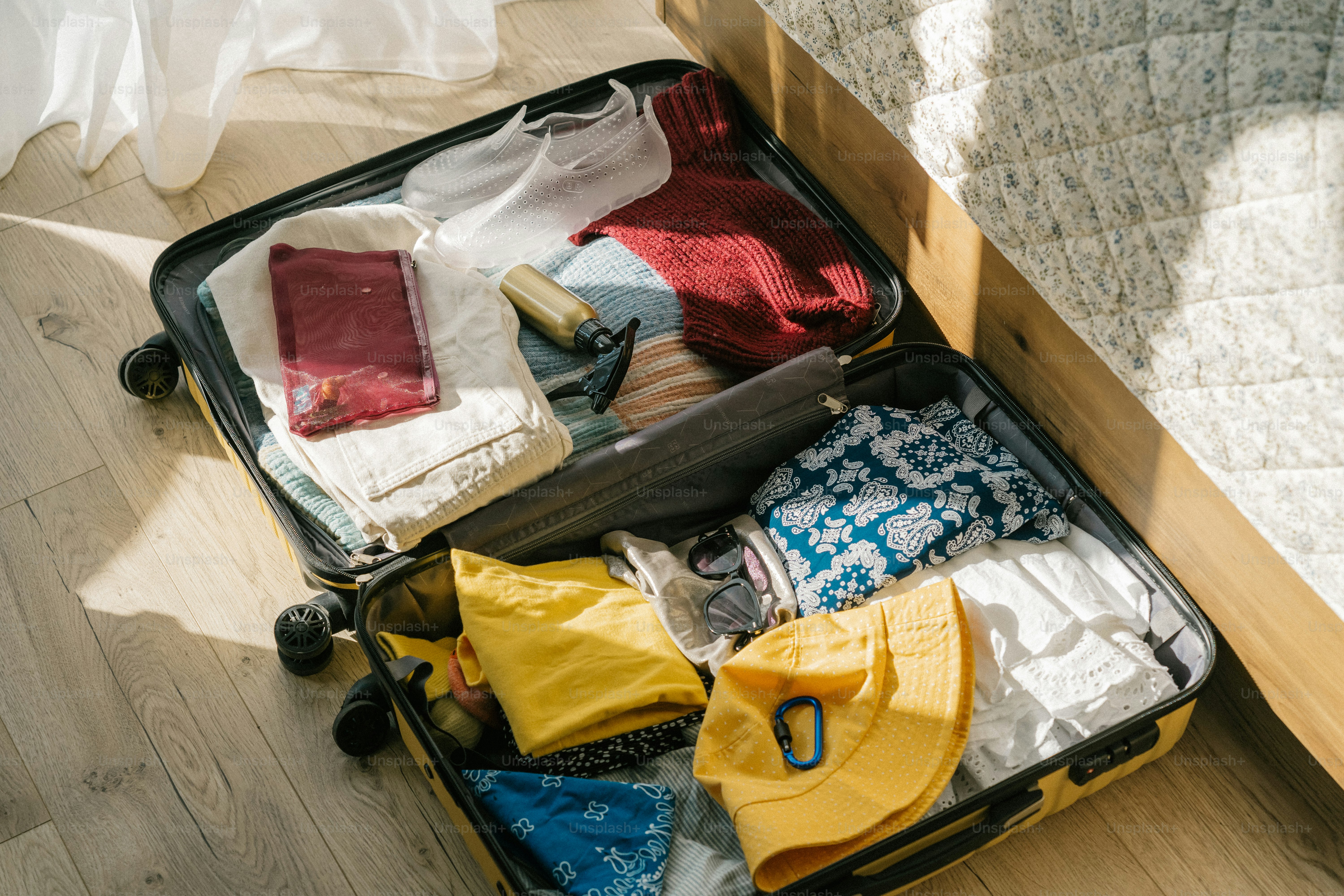 An open suitcase packed with clothes and travel essentials.